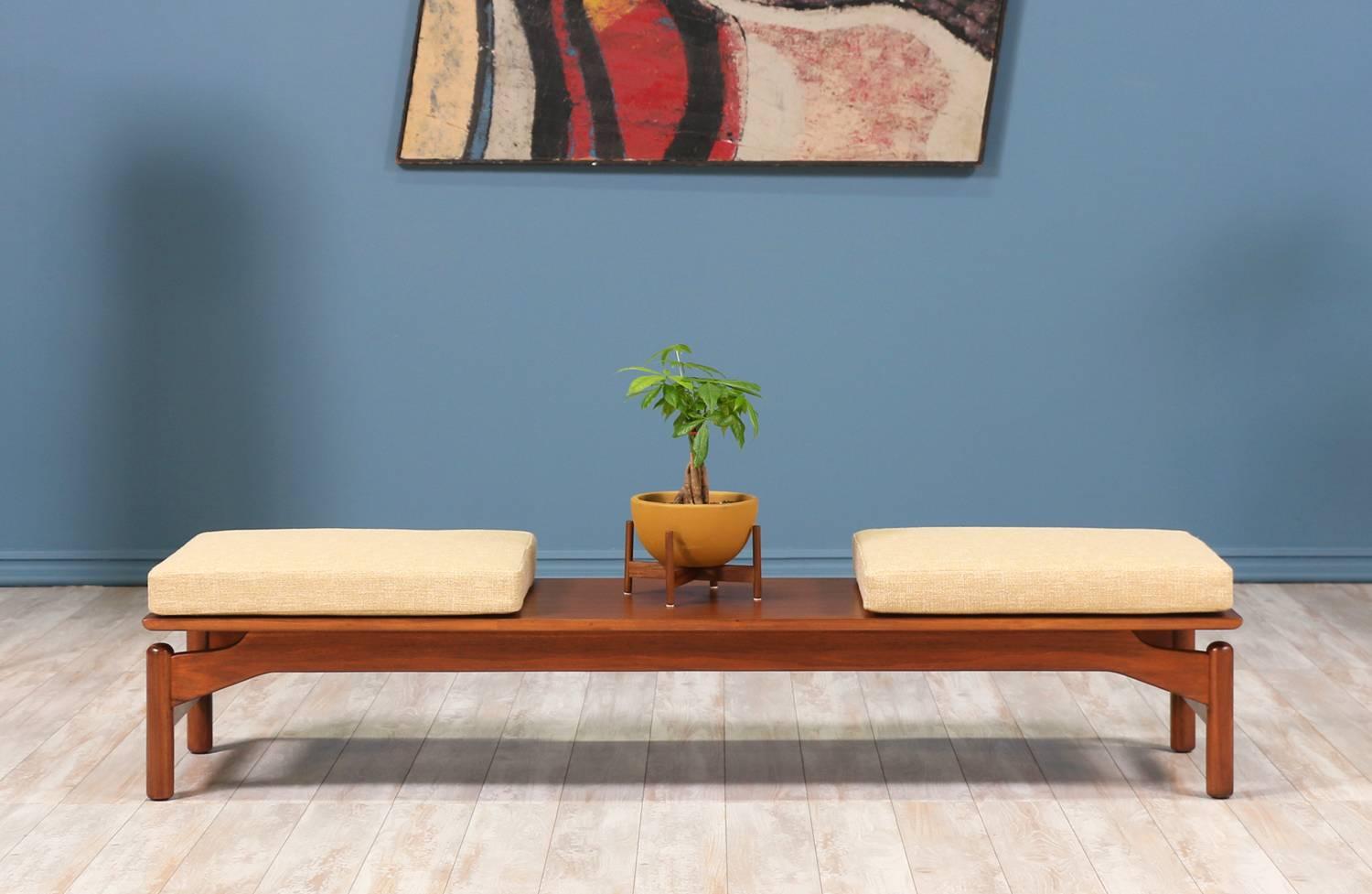 Mid Century Modern bench or coffee table designed by Greta M. Grossman for Glenn of California in the United States circa 1950’s. This practical design features a newly refinished walnut wood frame with cylindrical legs and sculptural stretchers