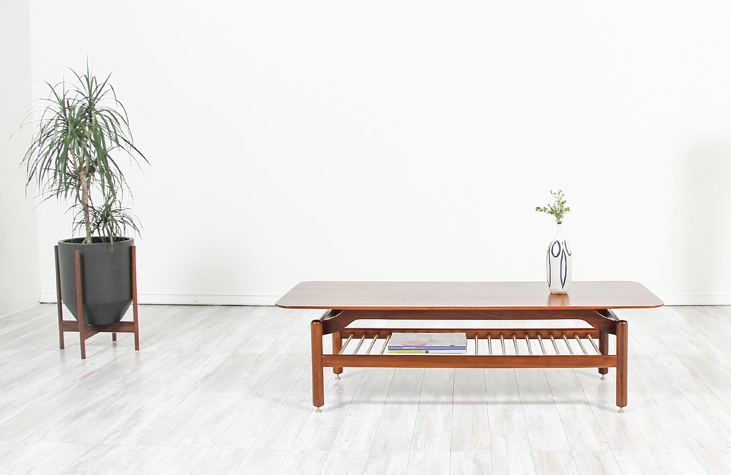 Stylish modernist coffee table designed by Greta M. Grossman for Glenn of California in the United States, circa 1950s. This stunning two-tier coffee table features a solid walnut wood frame and top with oakwood slats that work as a lower shelf for