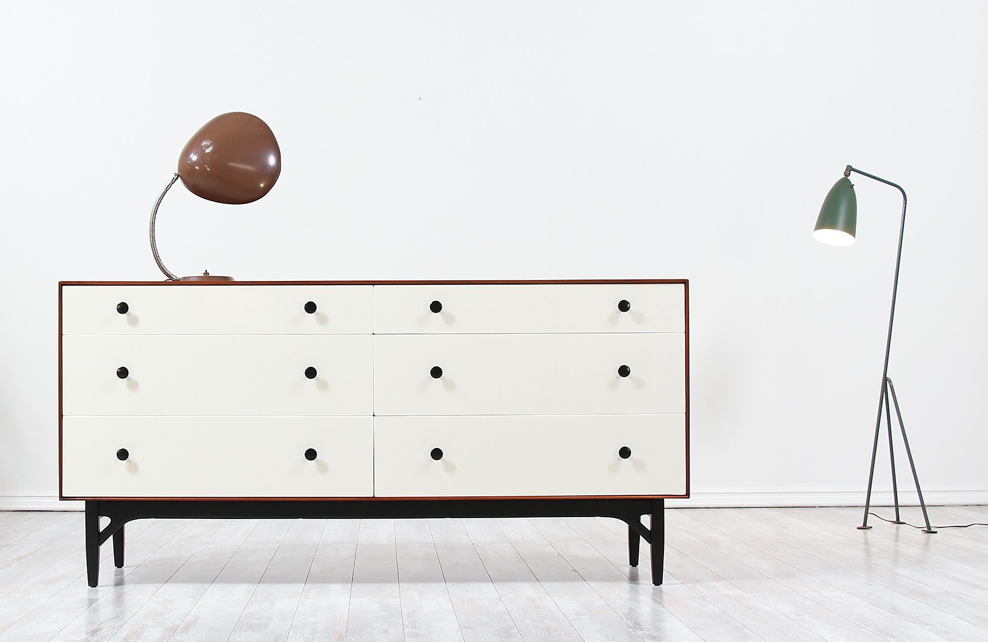 Elegant lacquered dresser designed by Swedish architect Greta M. Grossman for Glenn of California in the United States, circa 1950s. This rare original and iconic design is constructed of a walnut wood case that sits on an ebonized base featuring