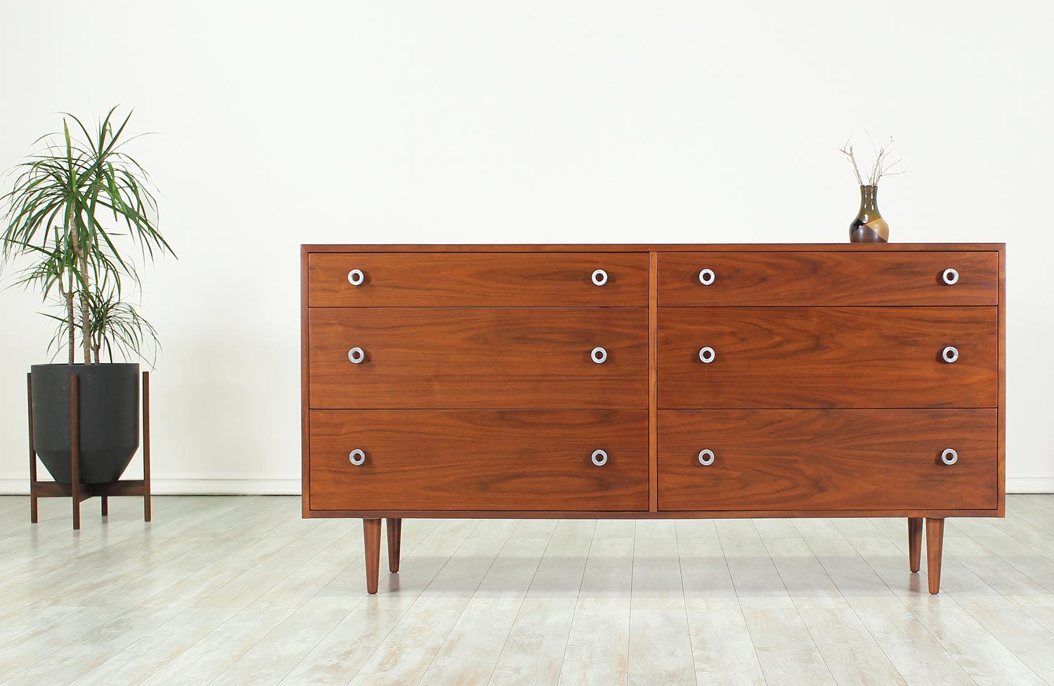Beautiful dresser designed by Greta M. Grossman for Glenn of California in the United States, circa 1950s. This elegant dresser is comprised of walnut wood and features six spacious dovetailed drawers in a case that sits over four sturdy tapered