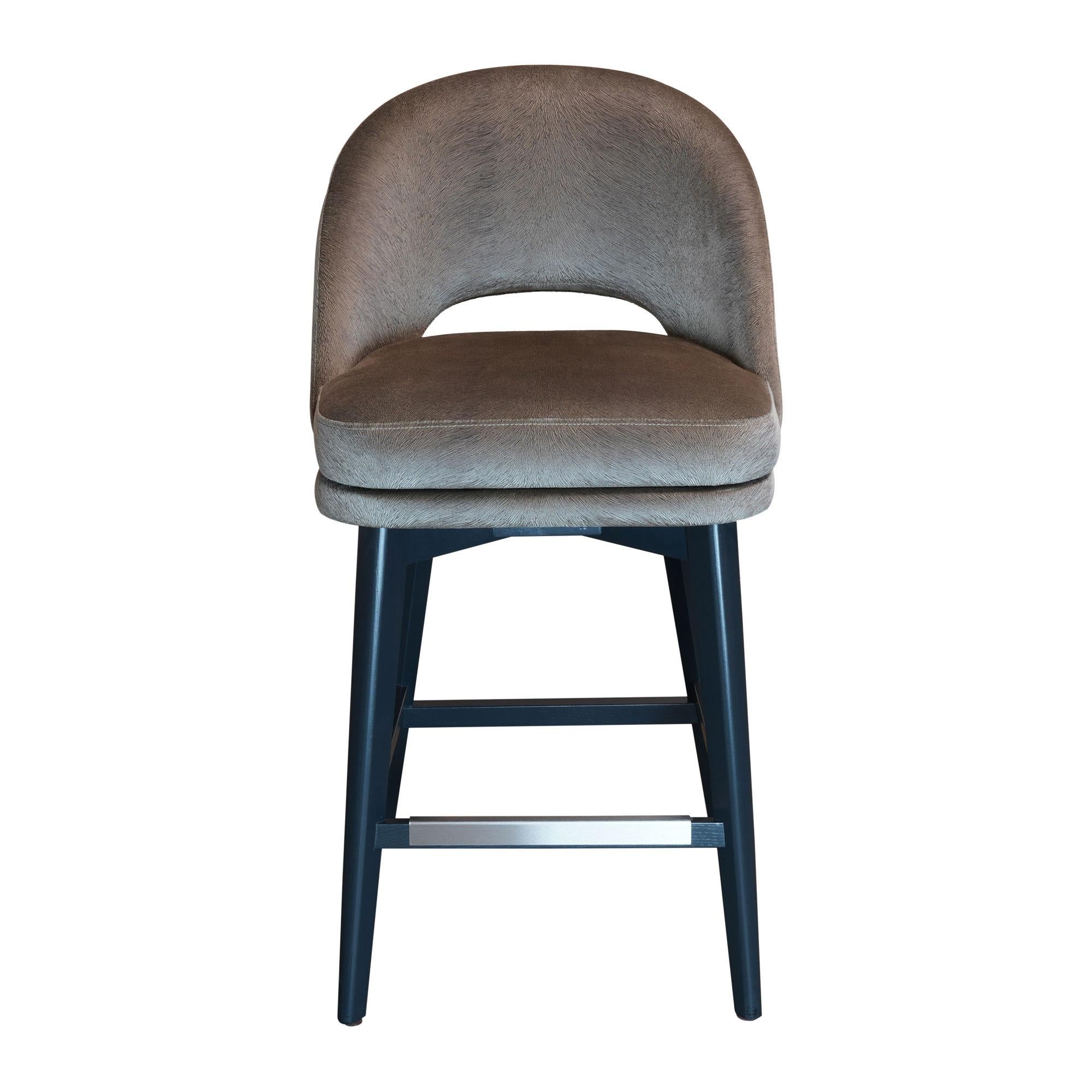 Counter stool with dark wenge stained beech legs, fully upholstered seat and back and brass footrest. COM.
Available in counter or bar height and totally customizable including finish, wood, metal and COM. Leather and fabric options available at an