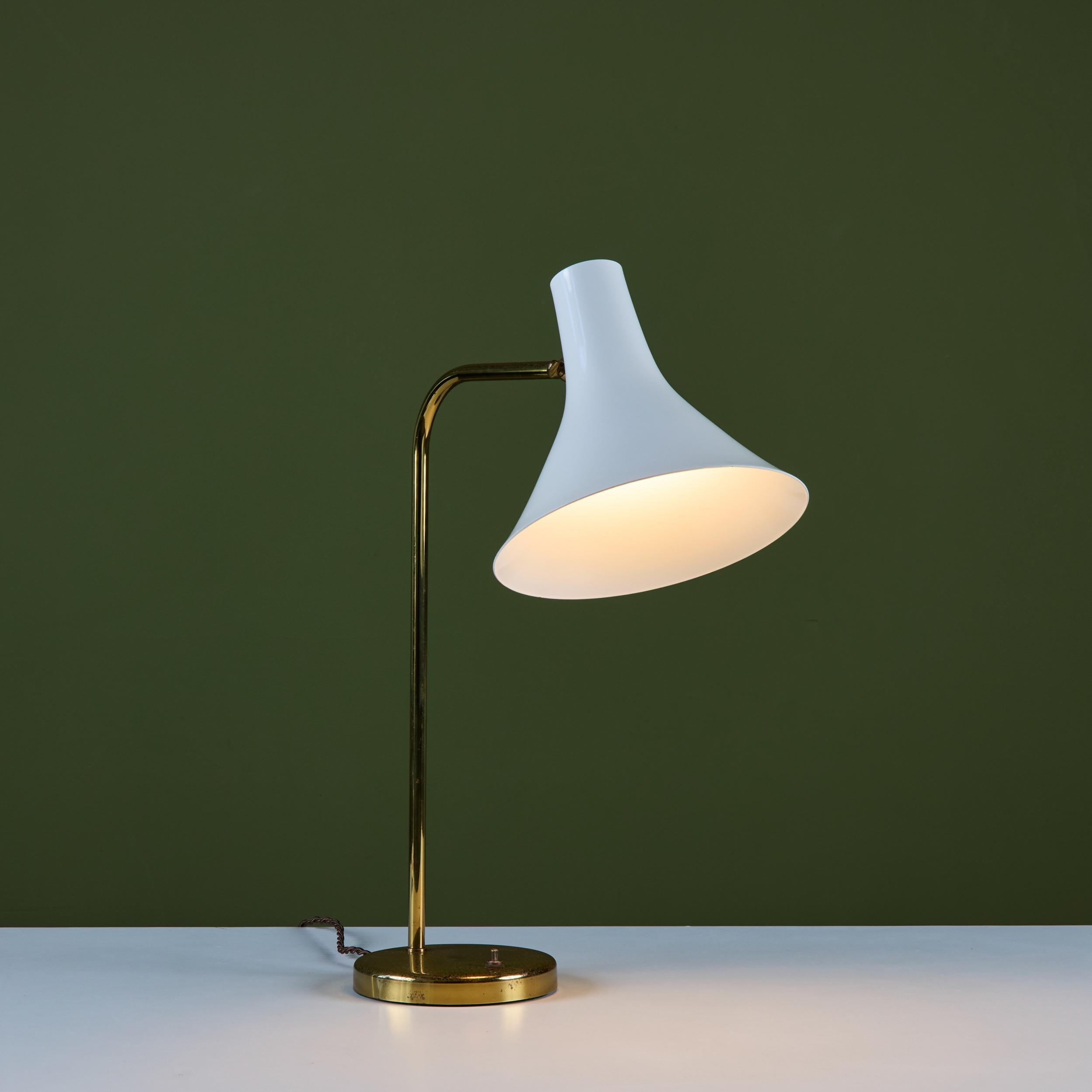 Schreibtischlampe, entworfen von Greta von Nessen, ca. 1960, USA, für Nessen Studios. Die Leuchte verfügt über einen weiß emaillierten, nach oben und unten schwenkbaren Trompetenschirm mit einem gebogenen Messingarm, der sich um 90 Grad nach links