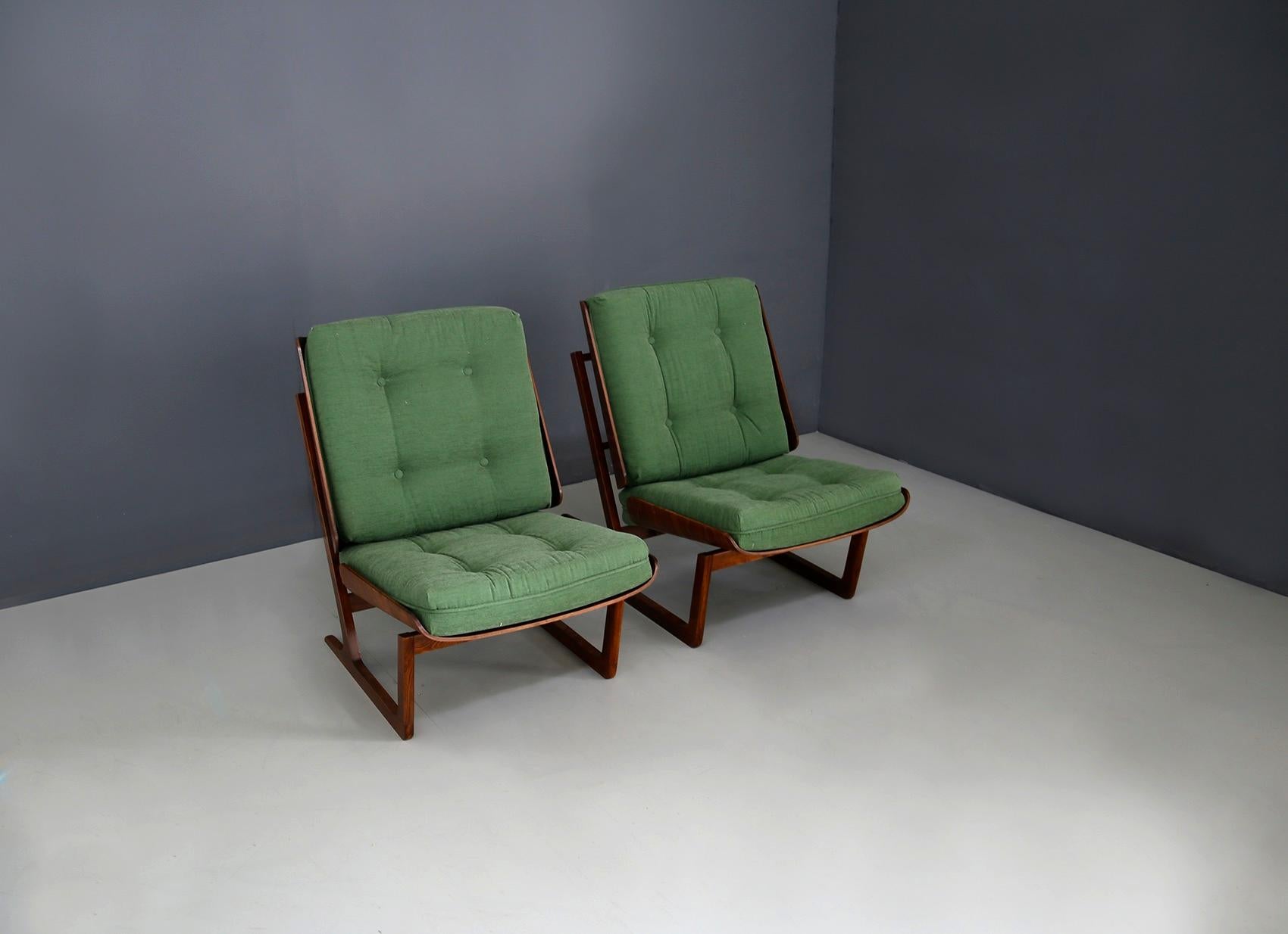 Pair of beautiful and eccentric armchairs attributed to Grete Jalk made in 1950. The pair is totally restored and beautifully crafted. Their structure is in mahogany veneer while the seat is covered in green cotton. Noteworthy is its support for its