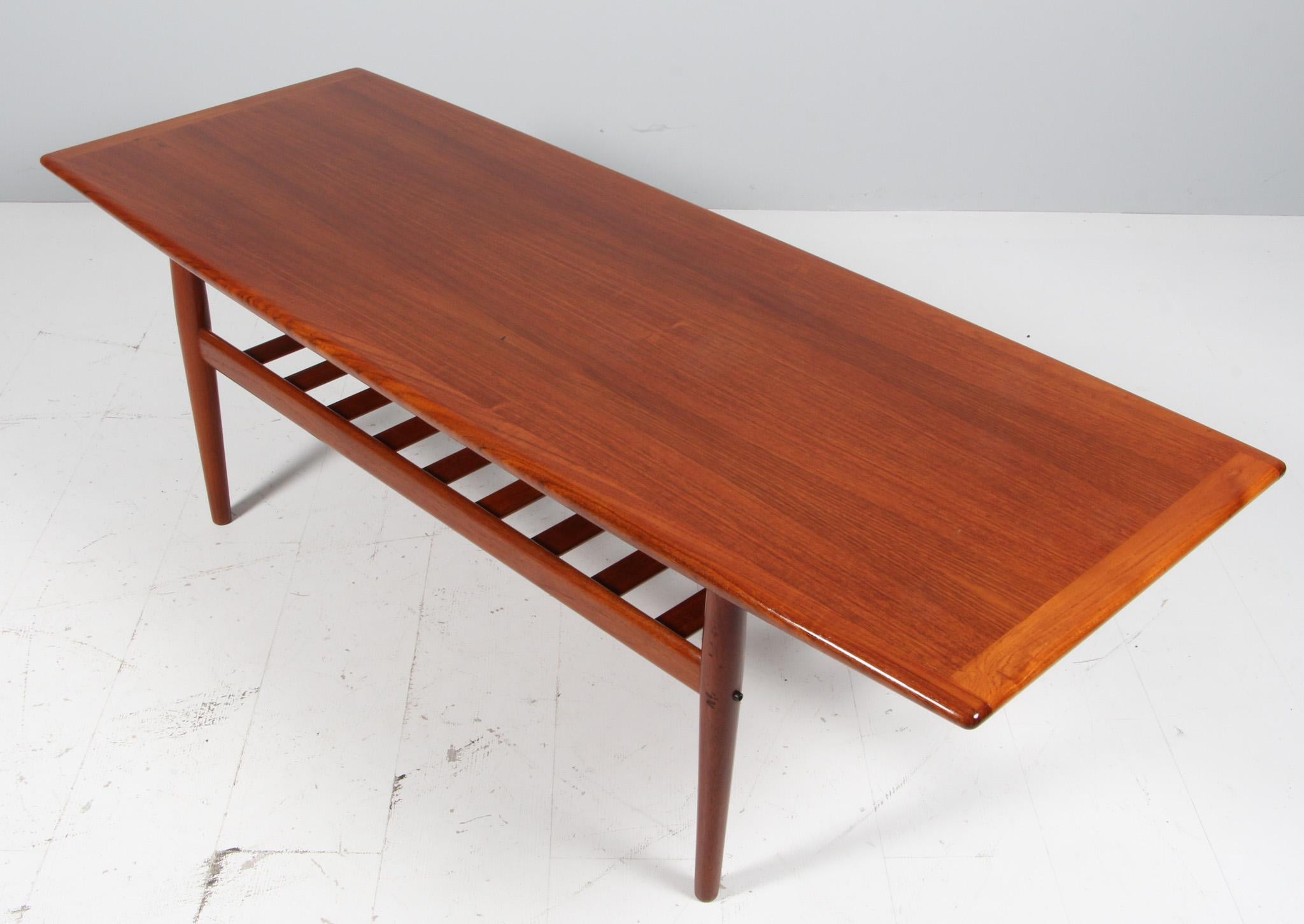 Grete Jalk coffee table in partly solid teak.

Made by Glostrup Møbelfabrik.