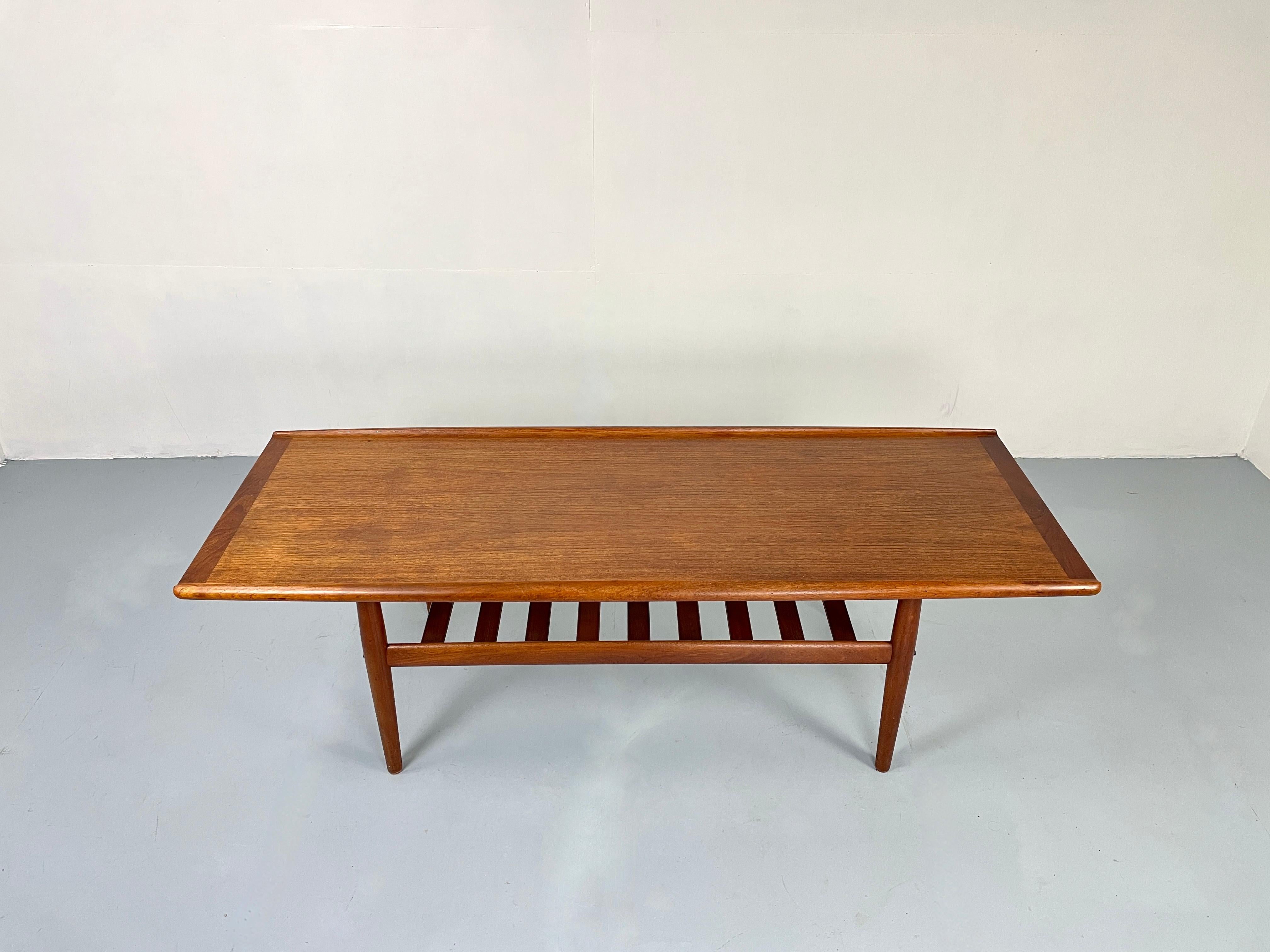 Iconic Scandinavian coffee table in beautiful teak.
The large coffee table has a shelf for magazines and fits perfectly with larger sofas. 


The candleholders and the vase are not included.