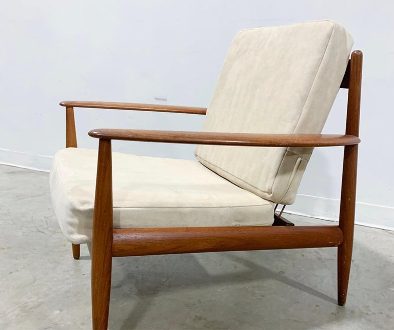 Beautifully sculpted solid teak Danish modern lounge chair by Grete Jalk for France and Daverkosen. This early version features an uncommon coil spring back, which makes this chair stand out for its minimalist design. France and Daverkosen 'Made in