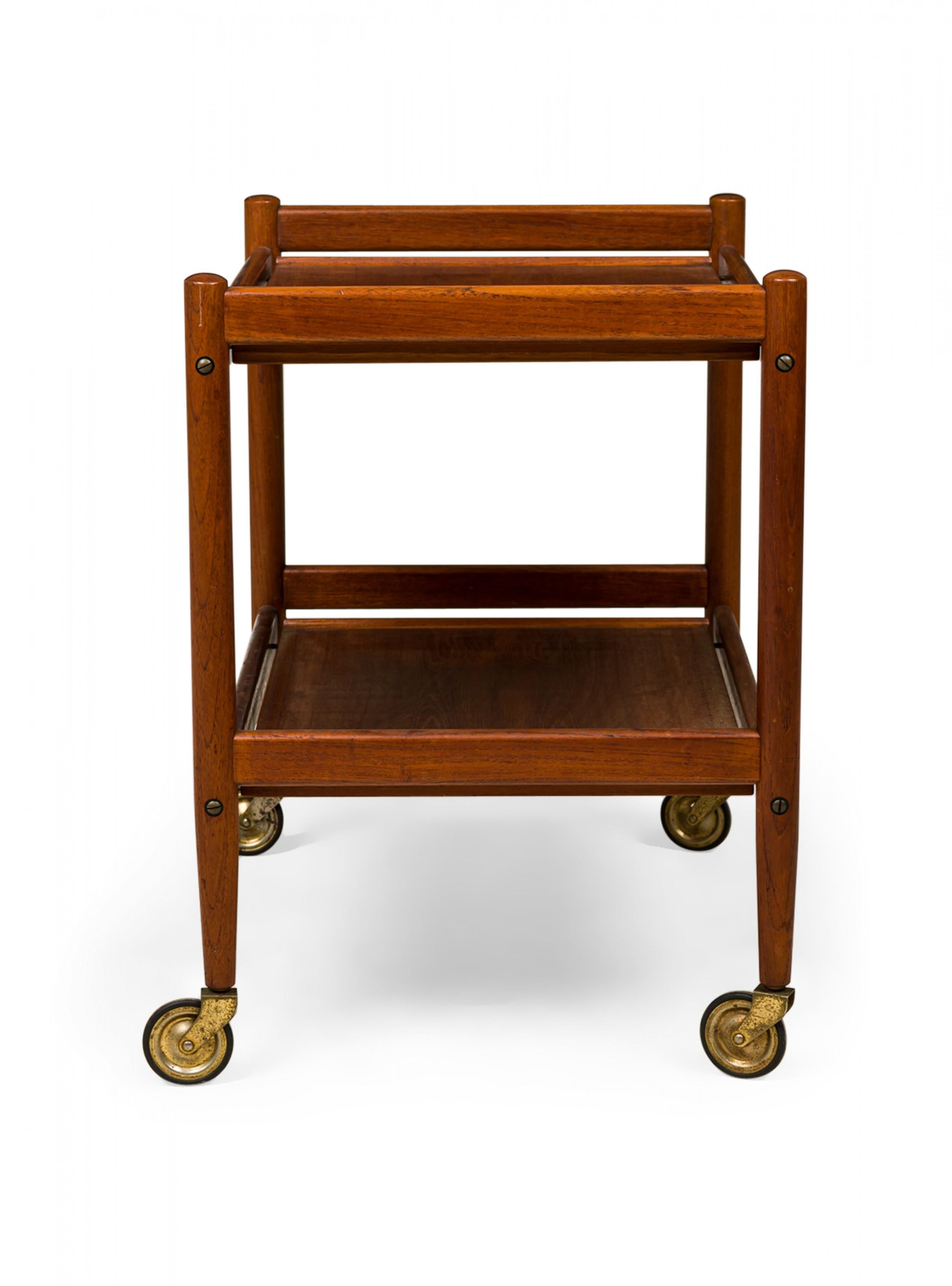 Danish mid-century teak wood serving trolley / tea cart with a rectangular form and two tiers, resting on four casters. (Grete Jalk).