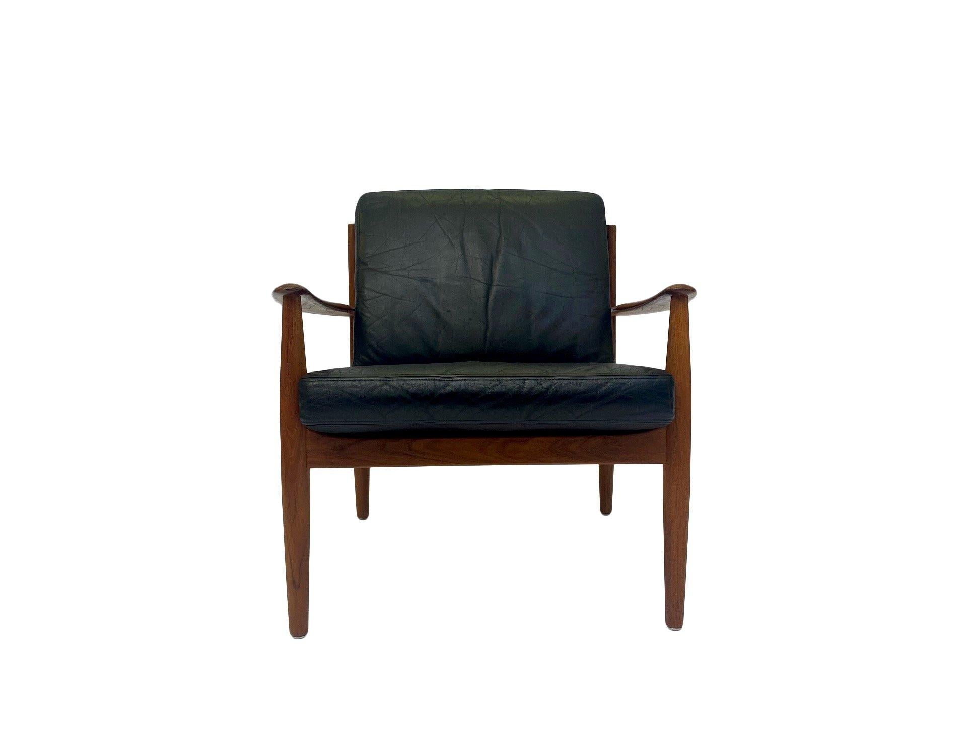 A beautiful Danish iconic teak and black leather lounge armchair designed by Grete Jalk for France & Søn in the 1960s, this would make a stylish addition to any living or work area. A striking piece of classic Scandinavian furniture.

The chair is