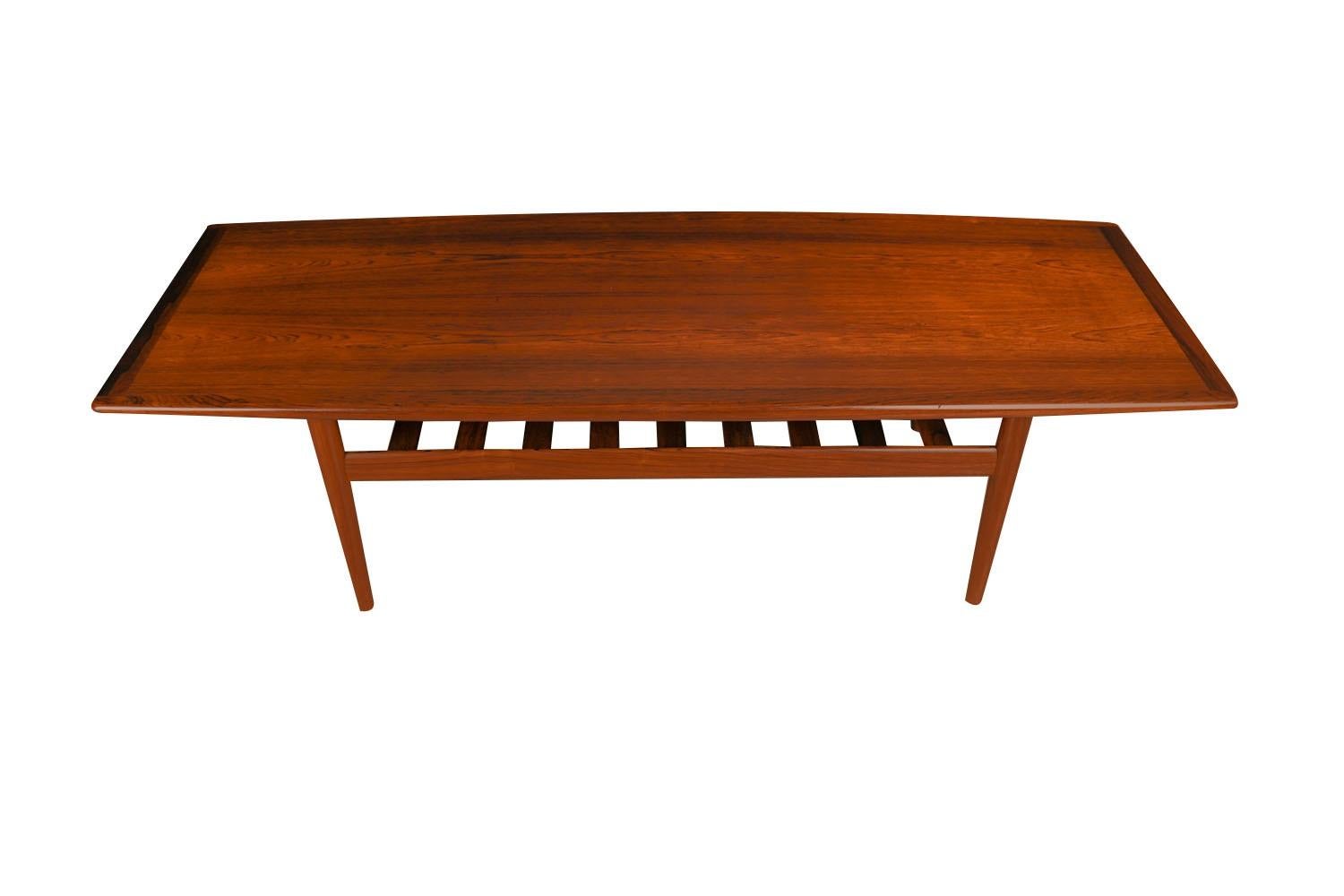 Une belle table basse danoise en bois de rose, moderne du milieu du siècle dernier, réalisée par Grete Jalk pour Glostrup Mobelfabrik, vers les années 1960. La longueur parfaite à associer à un canapé extra long. Le plateau rectangulaire est doté