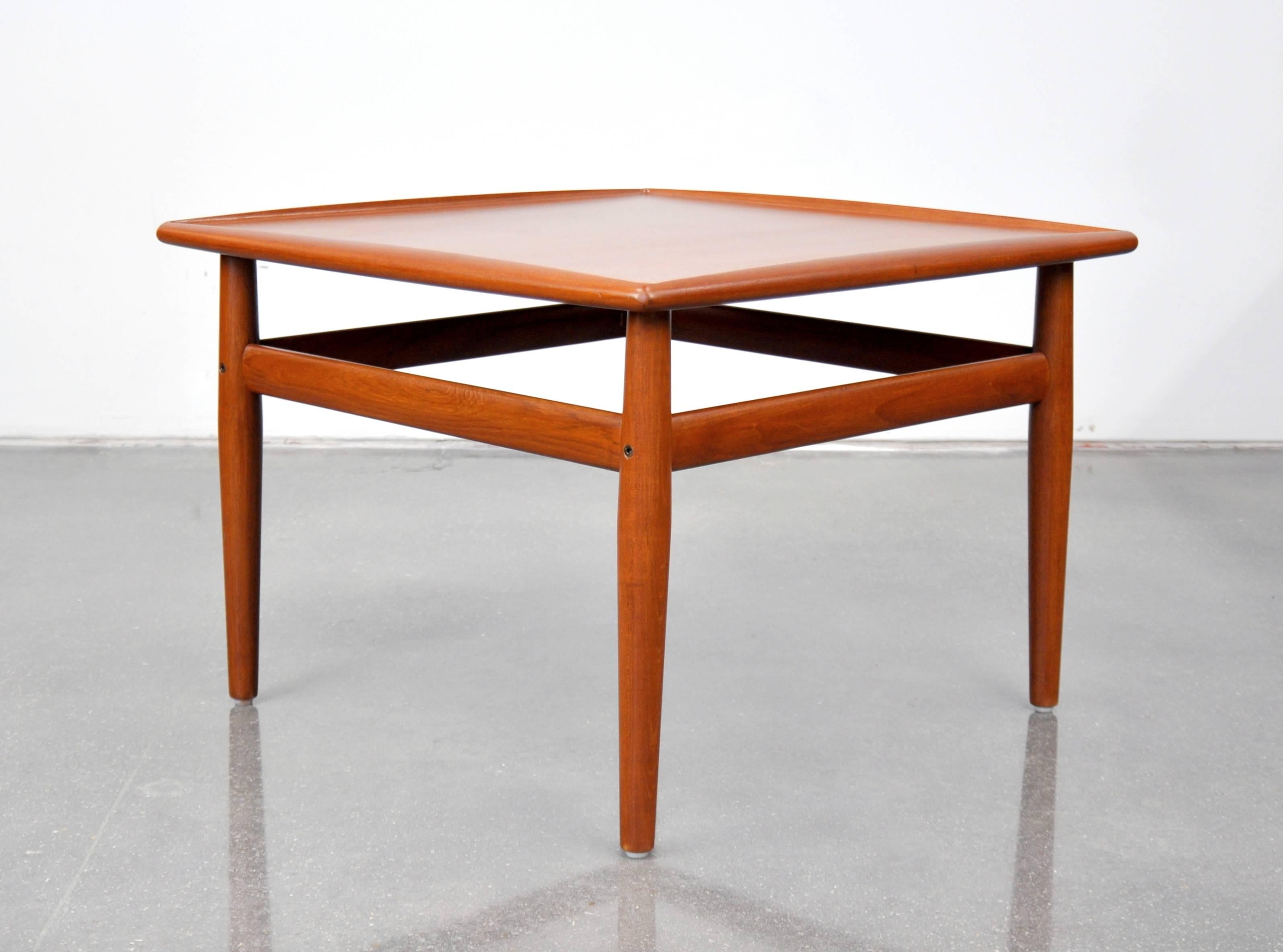 A pretty Danish Modern square occasional table that can be used as a coffee table. Designed by Grete Jalk for Glostrup, it dates from the 1960s. This Mid-Century Modern end or cocktail table features sculpted raised edges and inset brass details. A