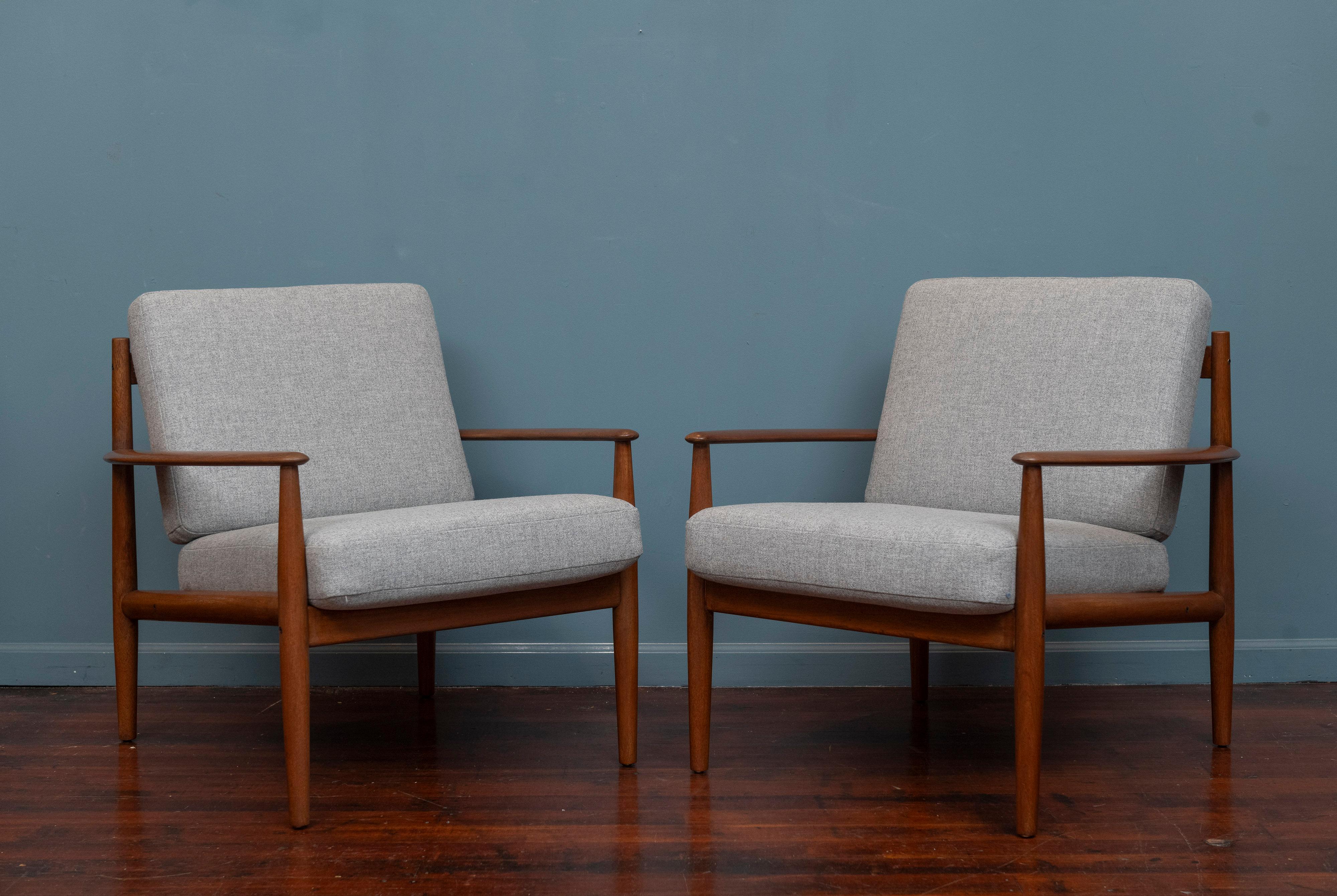 Grete Jalk design lounge chairs, Model 128 for France & Son Denmark. Beautiful design lounge chairs with curved arms and an attractive double splat back. Refinished teak wood frames just newly upholstered in 100% grey wool. These elegant chairs are