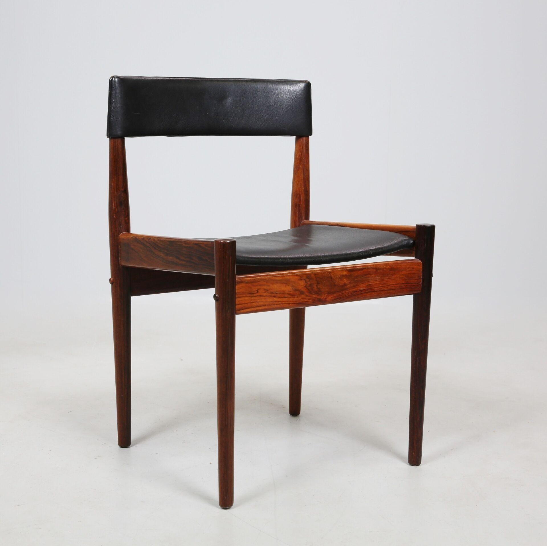 D'élégantes chaises en bois de rose massif et en cuir noir de la femme designer Grete Jalk. Produit dans les années 60 par l'ébéniste Poul Jeppessens. Nous avons 4 chaises disponibles et une table. 8 chaises supplémentaires sans cuir sur le dossier,