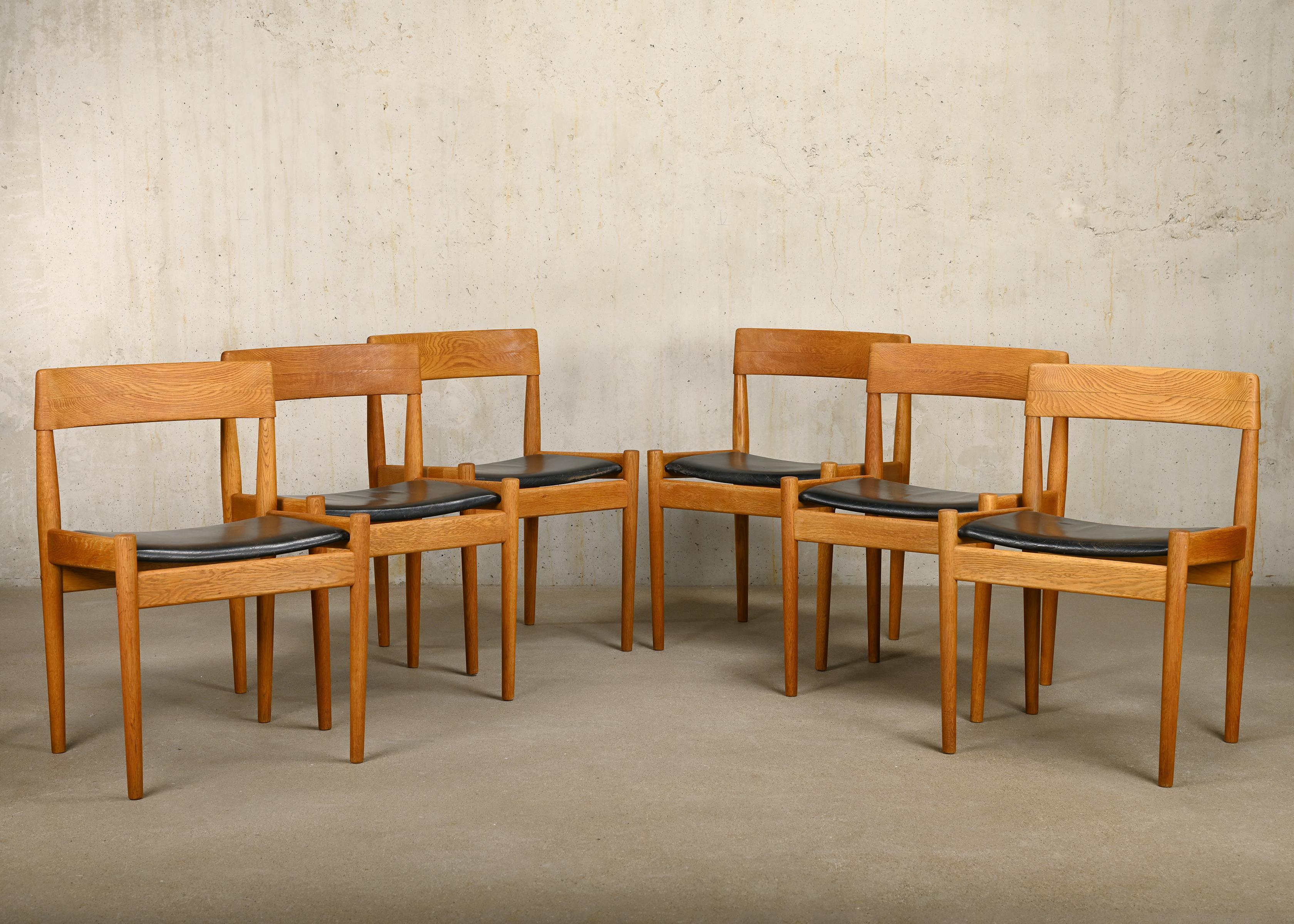 Set of 6 Dining Chairs designed by Grete Jalk model P J 3-2 for Poul Jeppesen Møbelfabrik, Denmark. Oak frames with black leather seats. The chairs are in good vintage condition with normal signs of wear and ageing.