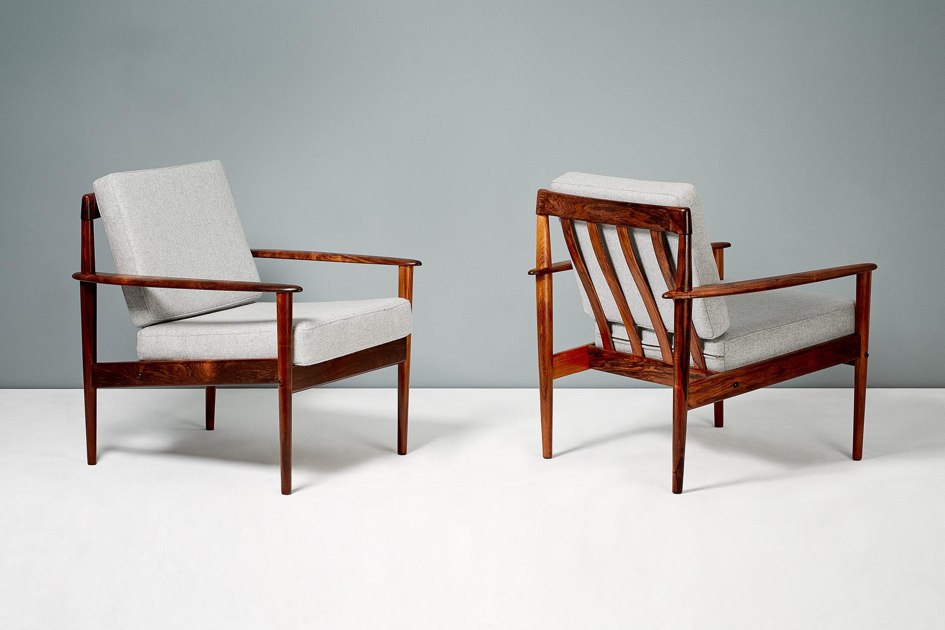 A pair of beautiful armchairs and matching ottoman designed by Grete Jalk for Poul Jeppesen, Denmark, circa 1956. These examples come in solid Brazilian rosewood with a particularly unusual, exotic grain. Danish furniture control badge and maker's