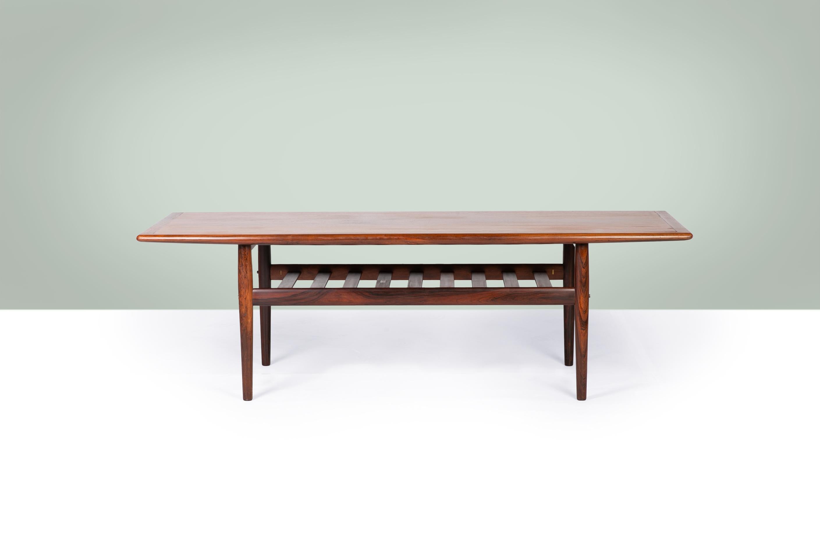 This elegant coffee table was designed by Grete Jalk in 1959 and produced by Glostrup Møbelfabrik in Denmark in the 1960's. Crafted from richly grained rosewood, it exemplifies the clean lines and refined craftsmanship of Danish modern design. The