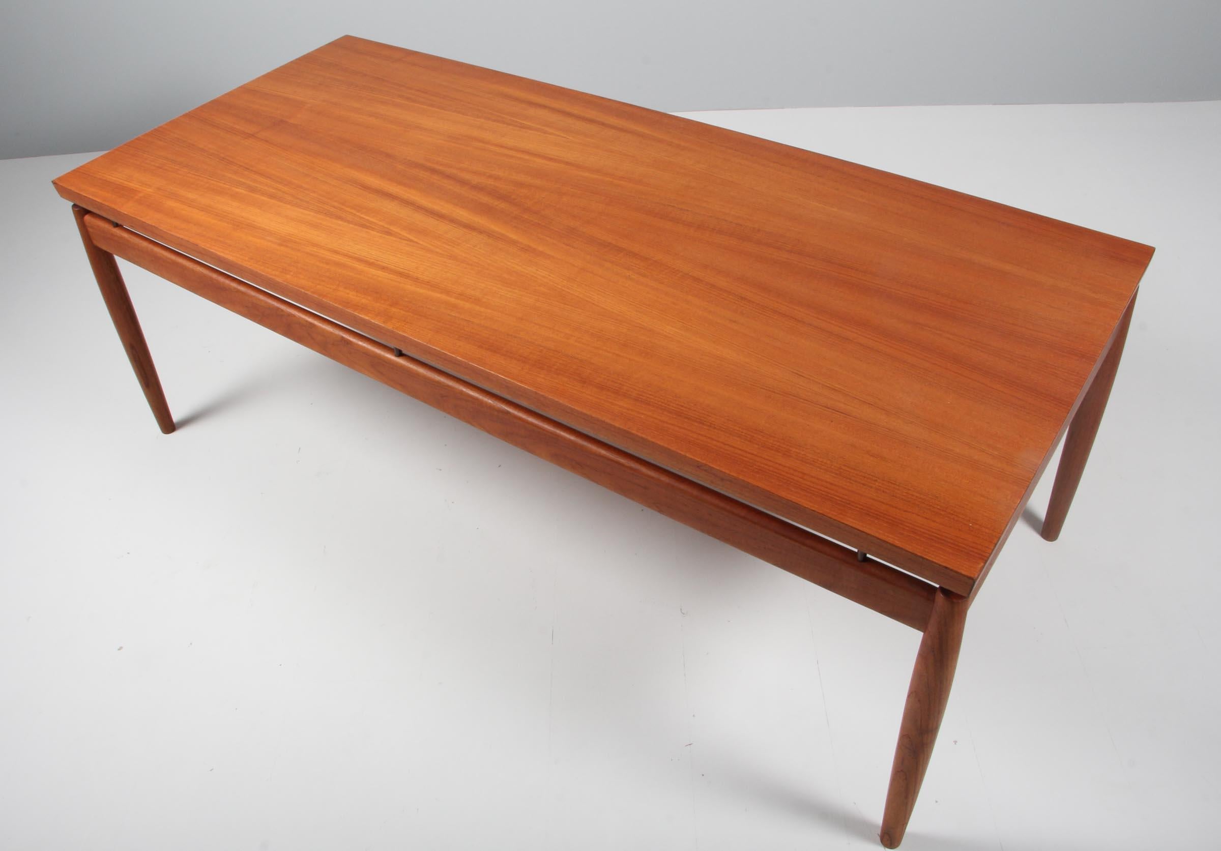 Grete Jalk sofa table with floating tabletop, tabletop held by brass pieces. Top of veenered teak, base of solid teak.

Model 622 / 54, made by France & Son in the 1960s.