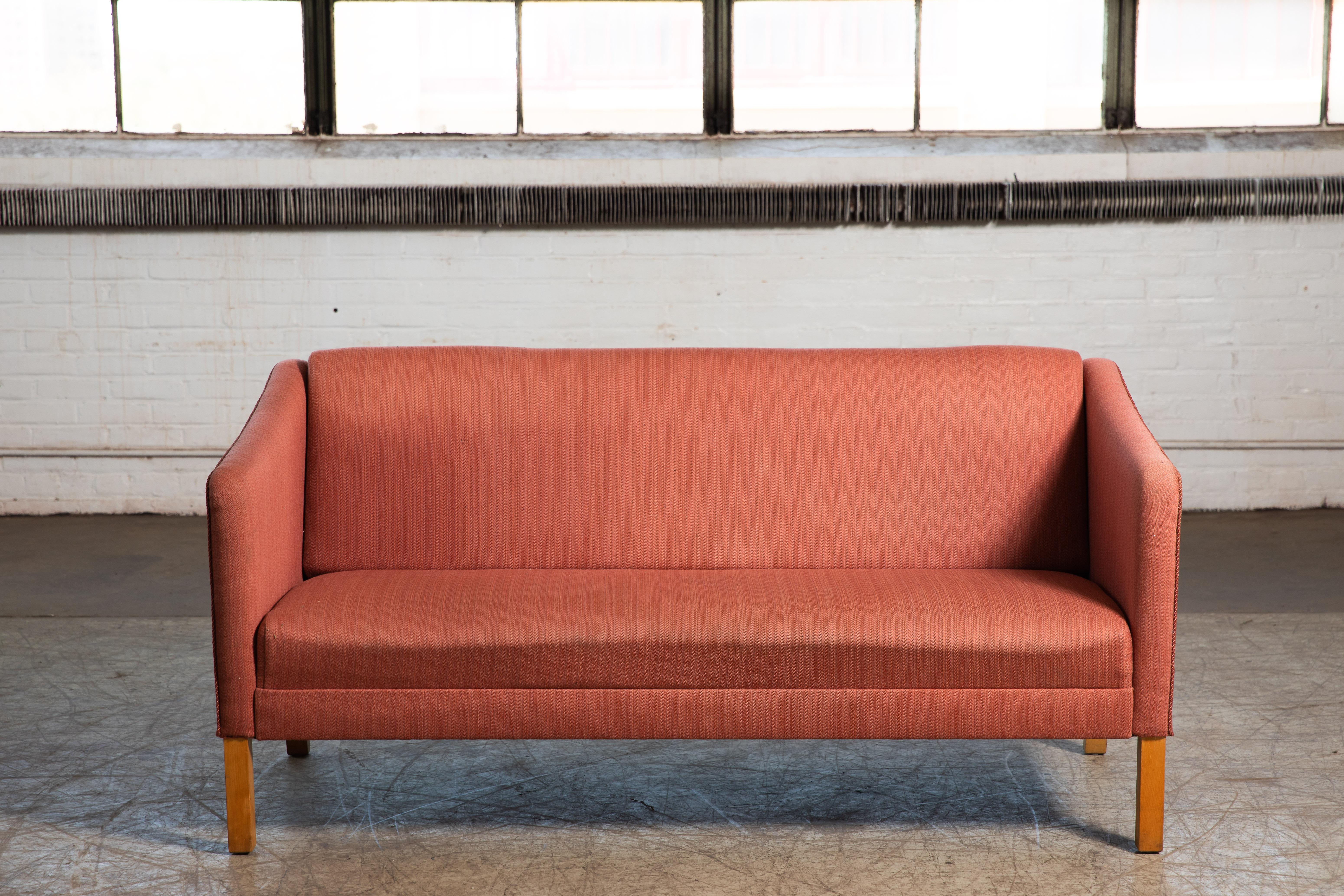 Handsome Danish two-seat sofa in the style of Grete Jalk similar in design to her JH 180 by Johannes Hansen. Simple yet very elegant and refined design beautiful from all angles. Supportive and comfortable raised on solid beech legs. Sofa