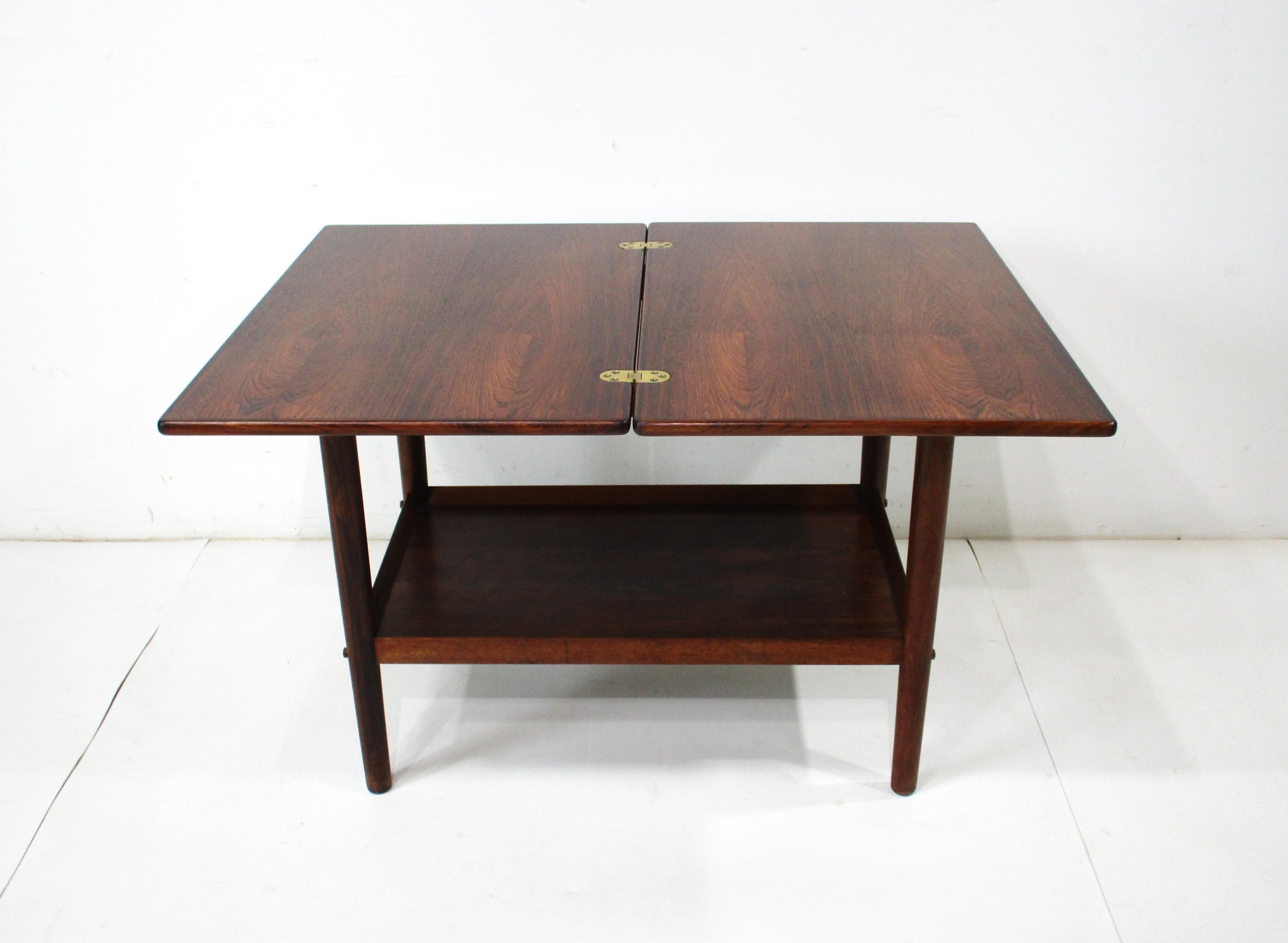 Très belle table d'appoint en palissandre avec quincaillerie en laiton, plateau pivotant et articulé permettant de l'agrandir et de l'utiliser comme table basse ou table d'angle. Le magnifique veinage du bois confère à la pièce un aspect et une