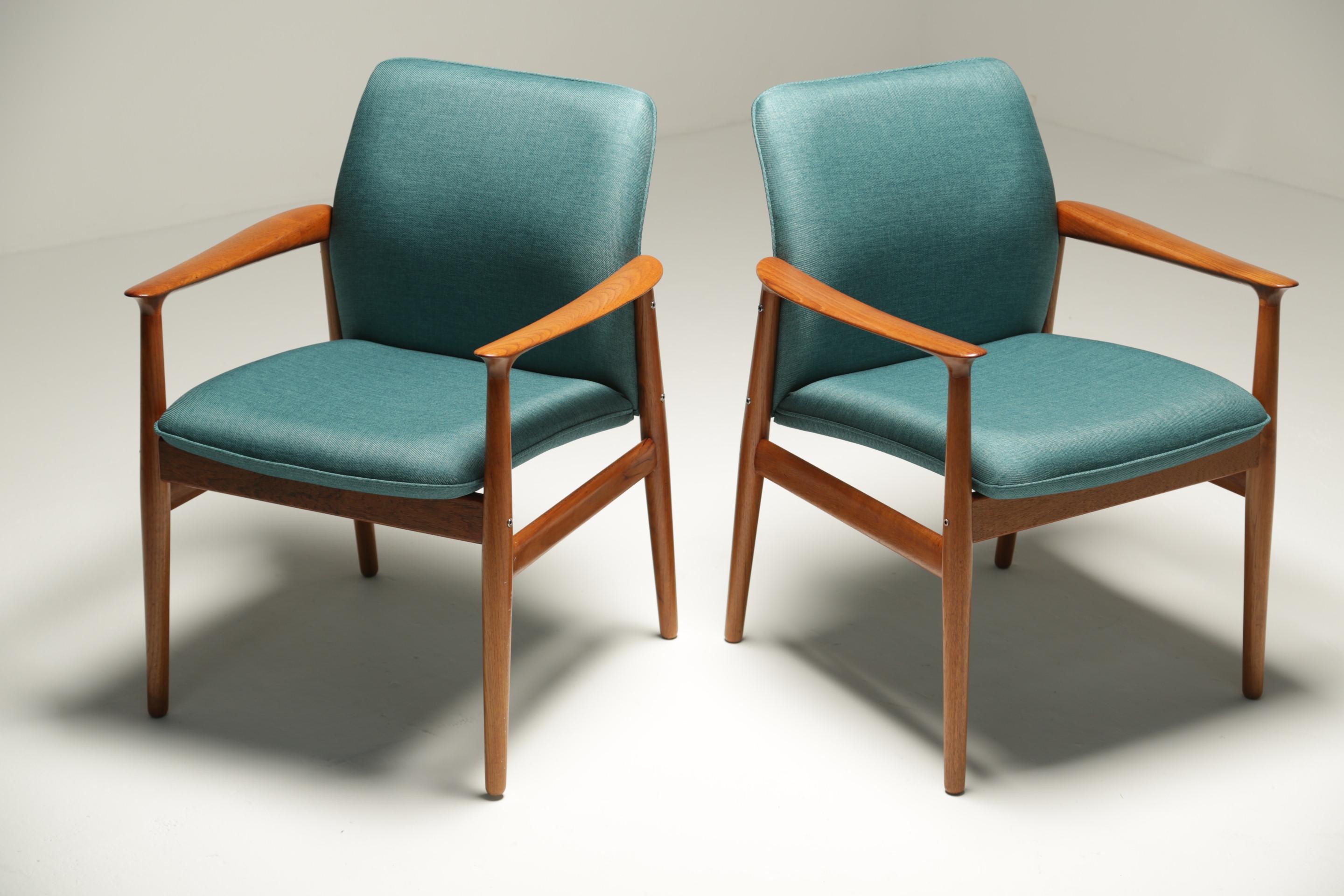A pair of Grete Jalk (pronouced Greata Yalk) teak armchairs. These chairs were produced in the 1960s by Glostrup and still have the original makers label on the frames. The chairs have been reupholstered in a modern teal fabric. A great pair of