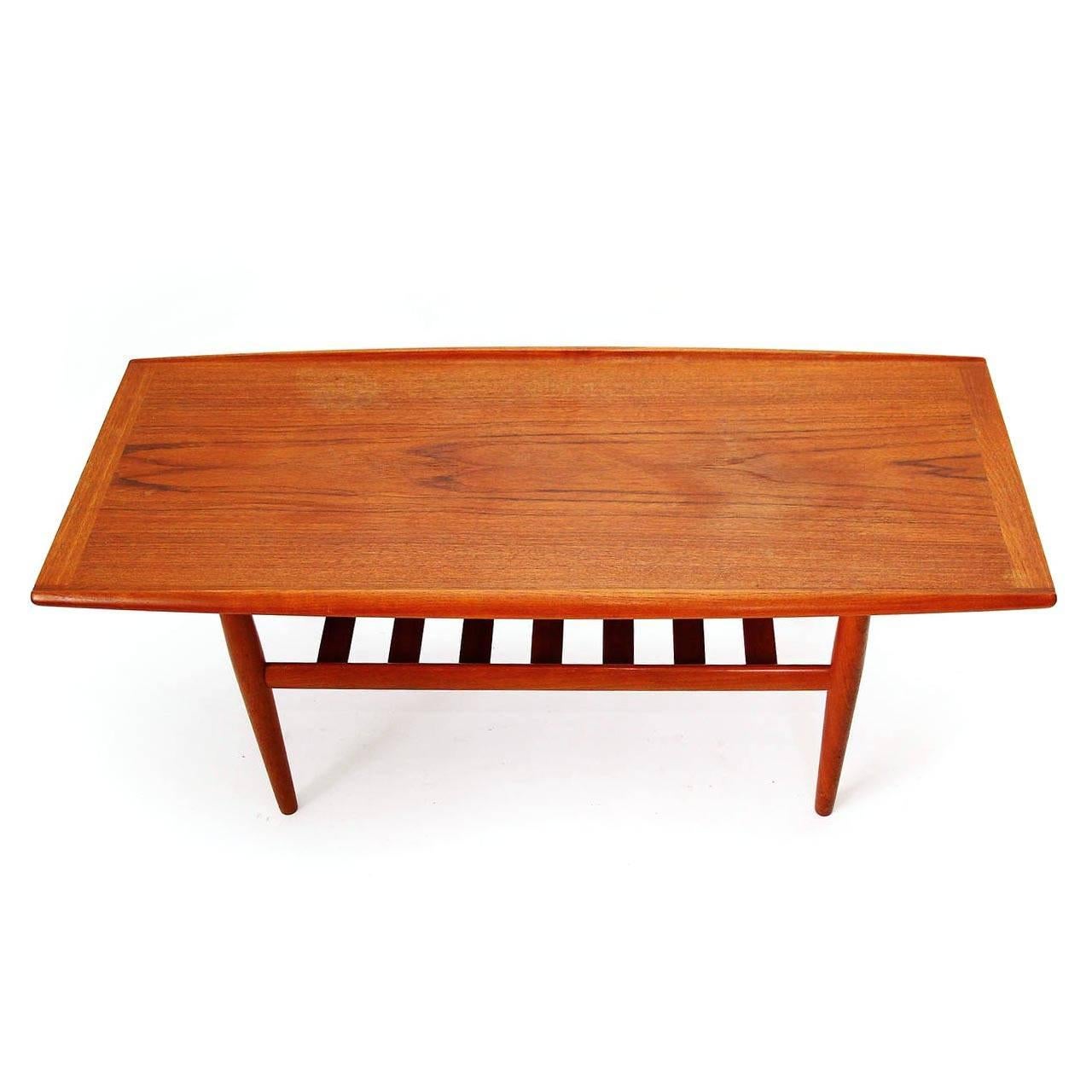 A Danish Modern teak coffee table with a shelf designed by Grete Jalk, Denmark, manufactured from Glostrup Møbelfabrik in midcentury, circa 1960.
The slatted shelf below the top is perfect for magazines or books.
The details and craftsmanship in