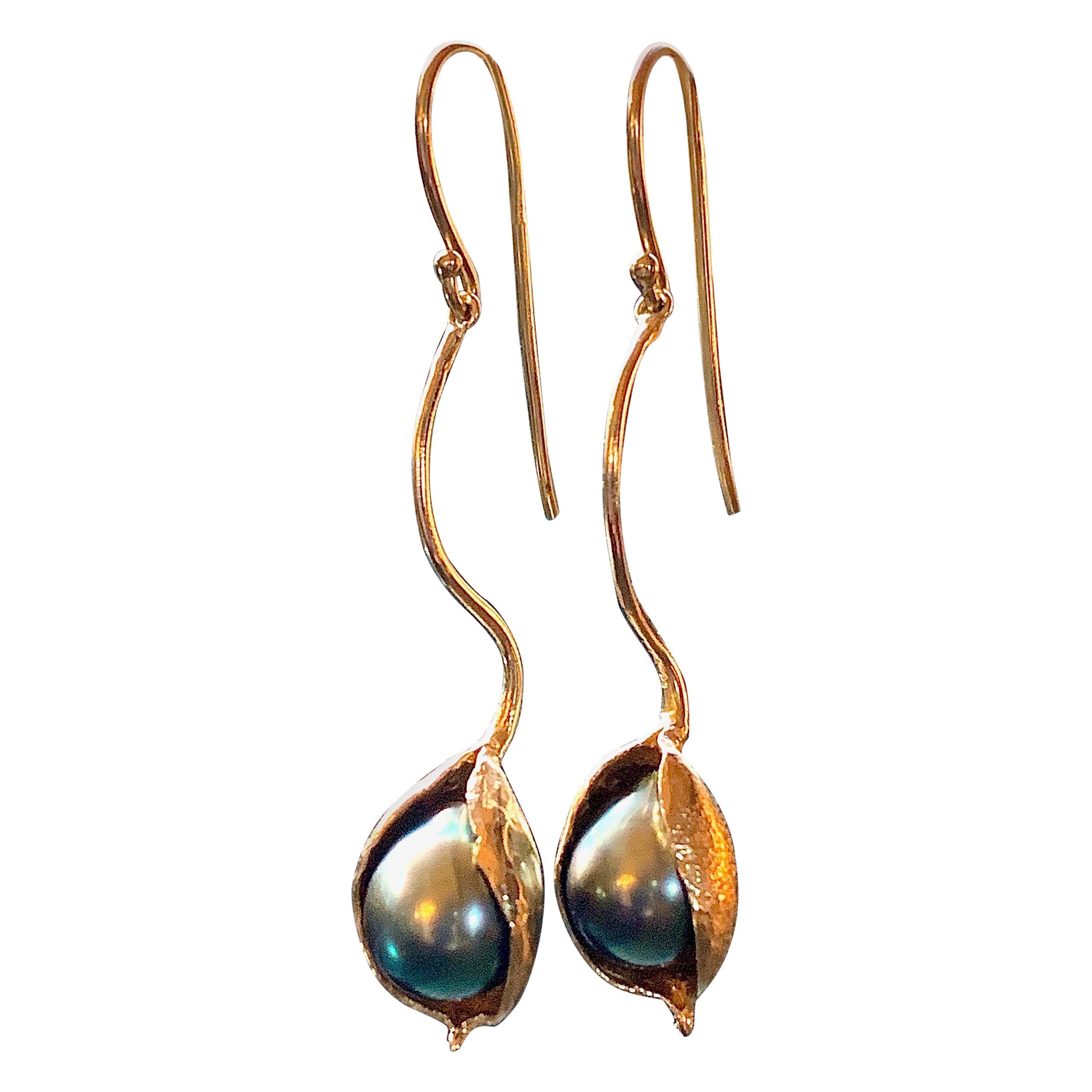Eytan Brandes used actual seed pods to make these long 14 karat yellow gold earrings.  The lustrous, purply green baroque Tahitian pearls are about 10mm each.  The pods are suspended on contoured wires hinged near the top to allow for movement. 
