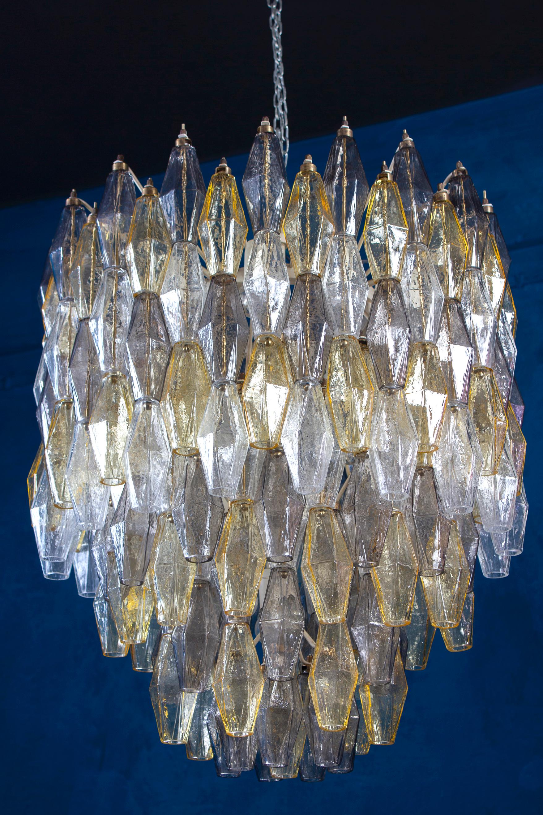 Fabulous original Polyhedral Murano glass chandelier. Rare combination of amber, grey and clear colored poliedri hanging from the metal tiers at several levels.
Ivory painted round shaped frame in very good and fully original condition.
The