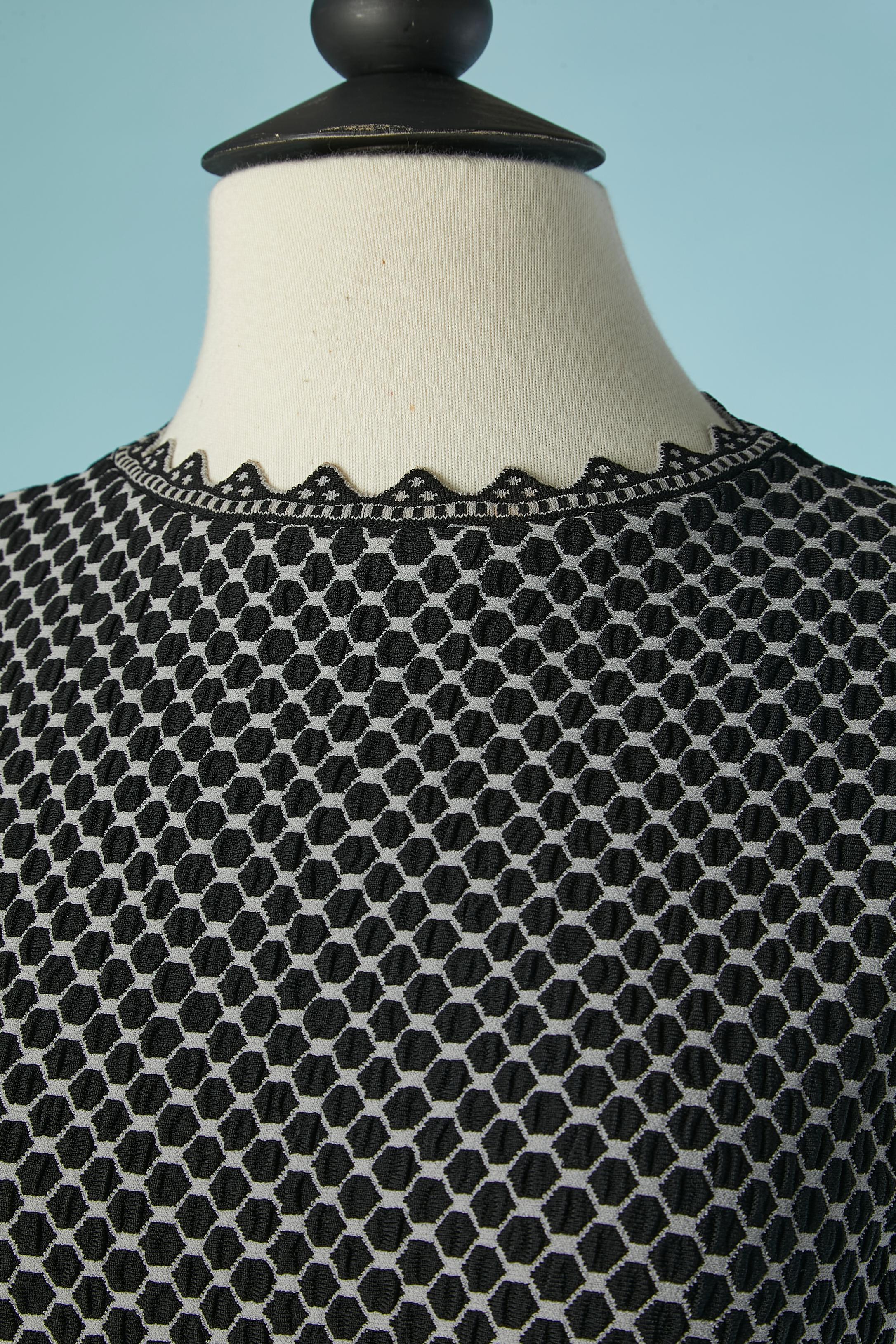 Graues und schwarzes Jacquard-Kleid ohne Ärmel. Zusammensetzung des Gestricks: 70% Viskose, 14% Polyester, 14% Nylon, 2% Stretch. 
Unsichtbarer Reißverschluss auf der linken Seite. 
GRÖSSE 38 (It) 34 (Fr) XS 