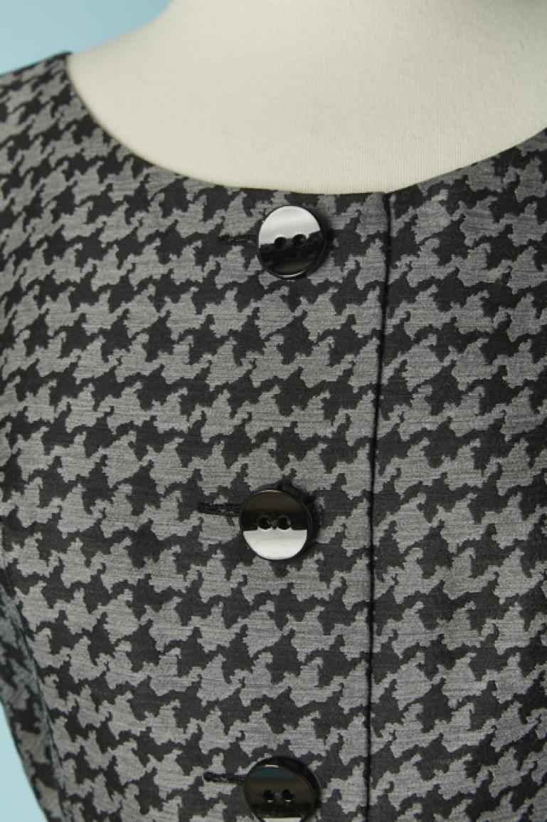 Grey and black Pied de coq pattern sleeveless cocktail dress with belt. Main fabric composition: 86% wool, 14% silk. Lining: 66% rayon, 34% silk. 
Belt in the same fabric with buckle and eyelet closure + belt-loop.
Zip and hook&eye closure on the