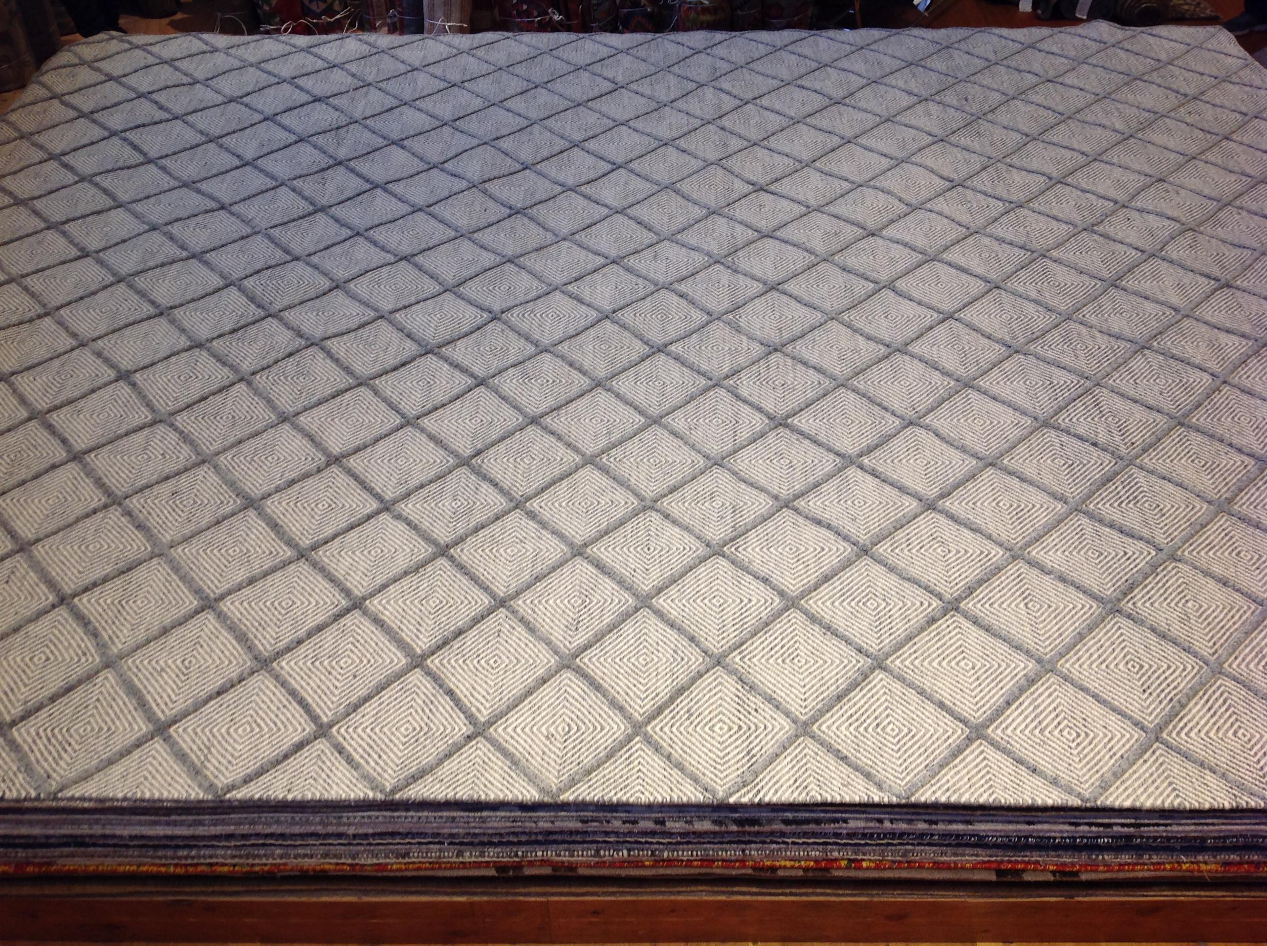Diamonds within diamonds star in this high low rug with both visual and tactile appeal. Hand knotted wool. Made in India.