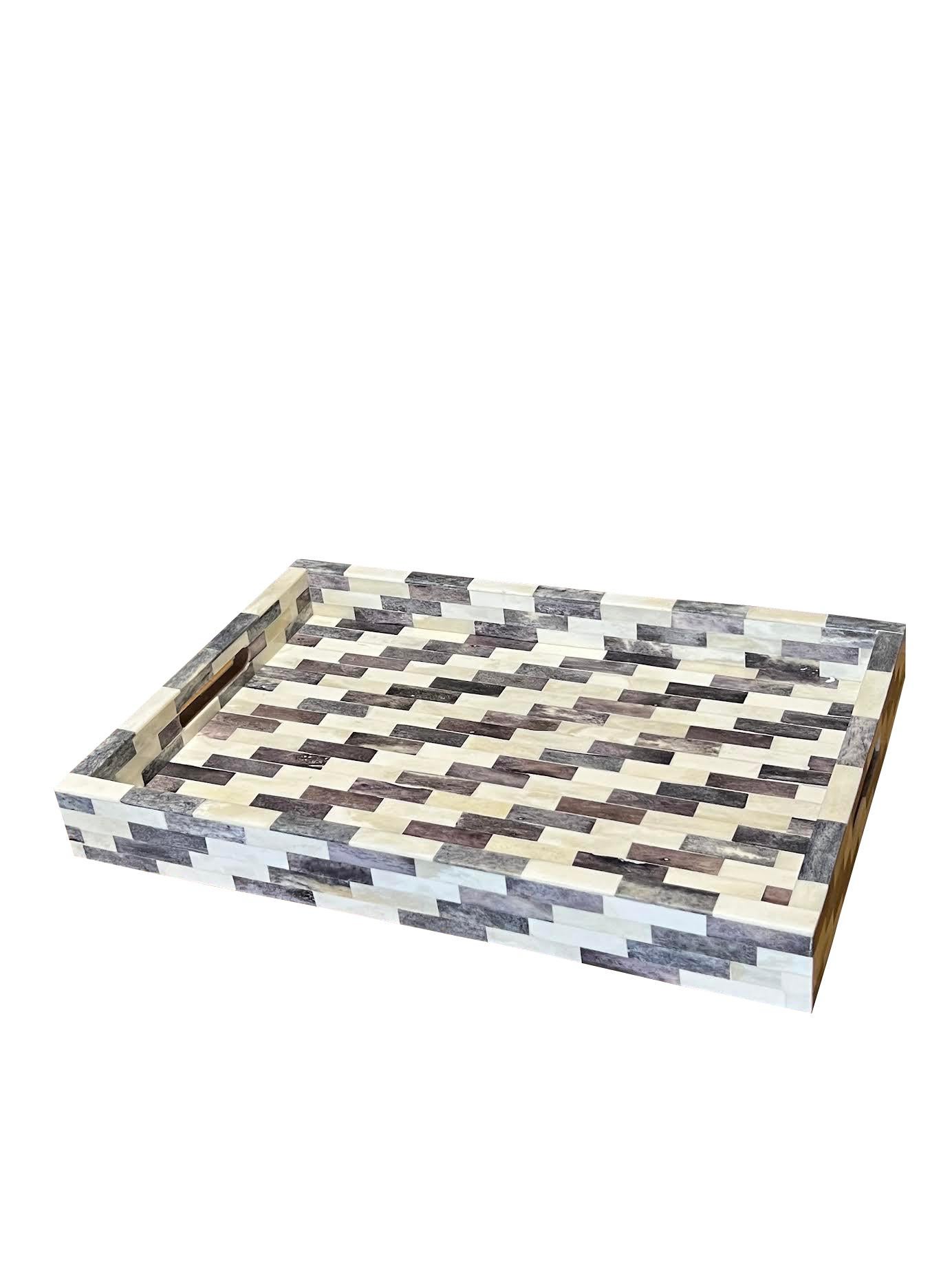 Vassoio indiano contemporaneo in osso grigio e crema dal design geometrico con manici intagliati.
Fa parte di un'ampia collezione di vassoi e scatole in osso