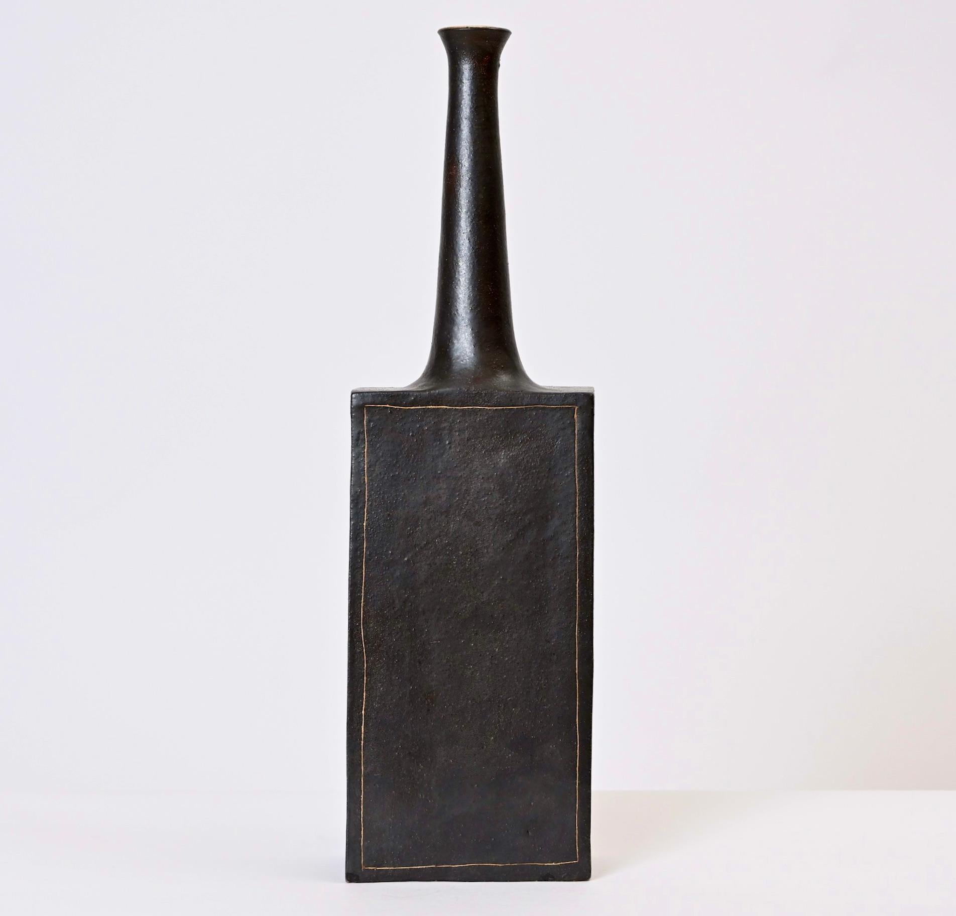 Ce vase en faïence émaillée de Bruno Gambone a été conçu et fabriqué dans le même atelier florentin que celui créé par son célèbre père céramiste, Guido. Produit dans les années 1970, ce vase haut et élancé est de couleur gris foncé et présente par