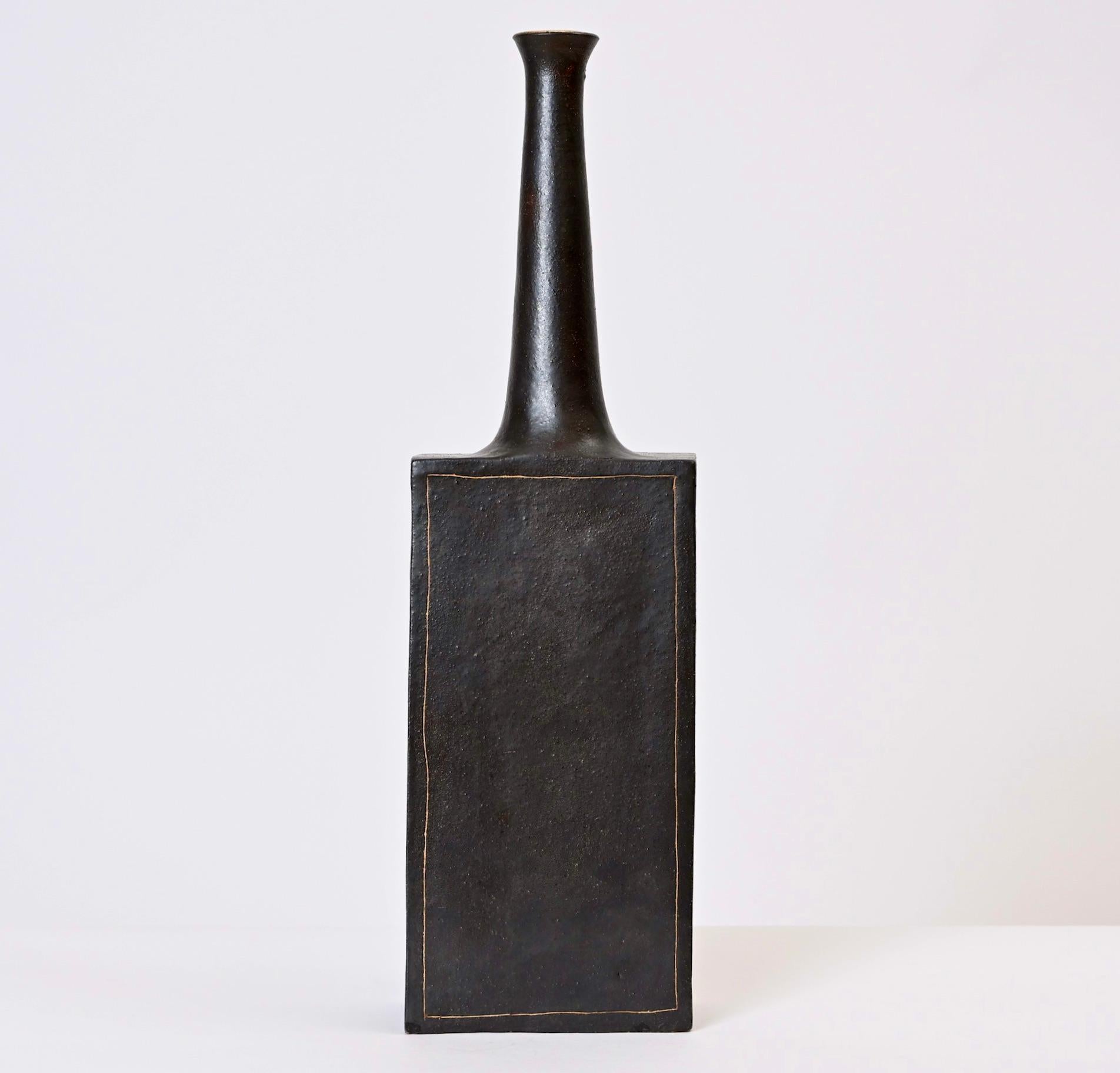 Ce vase en faïence émaillée de Bruno Gambone a été conçu et fabriqué dans le même Studio Florentine que celui de son célèbre père céramiste, Guido. Produit dans les années 1970, ce vase haut et élancé est de couleur gris foncé et présente une