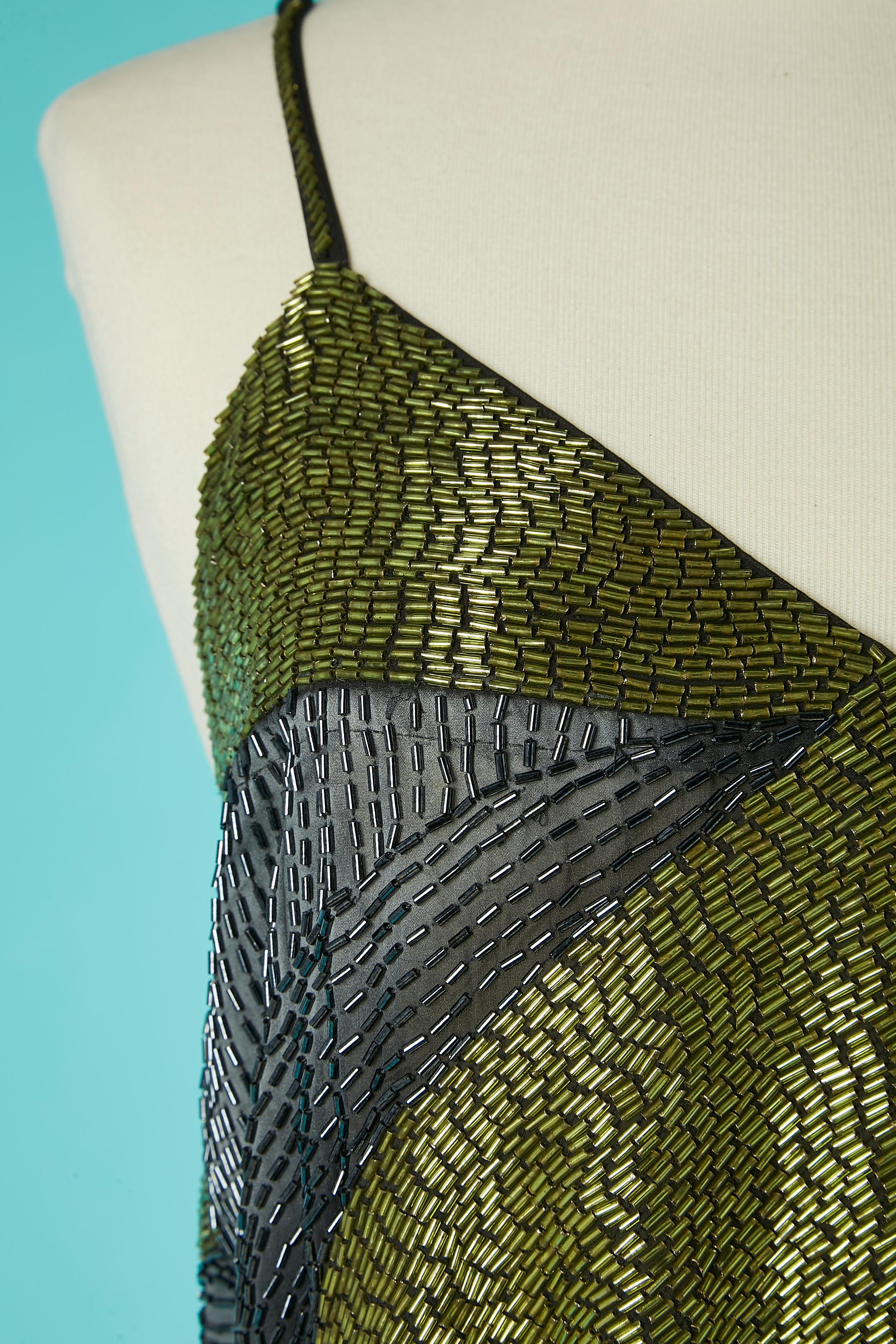 Robe de soirée entièrement perlée, grise et verte, sur une base de polyester. Fermeture éclair invisible au milieu du dos et crochets. 
Fente sur le côté gauche = 73 cm 
TAILLE 44 (I.L) 40 (Fr) L 