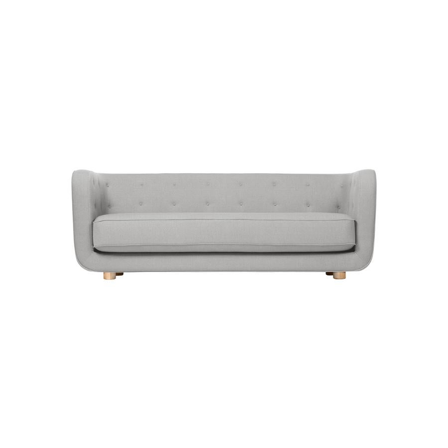 Sofá gris y roble natural Raf Simons Vidar 3 Vilhelm de Lassen
Dimensiones: Anchura 217 x Profundidad 88 x Altura 80 cm 
Materiales: textil, roble.

Vilhelm es un hermoso sofá acolchado de tres plazas diseñado por Flemming Lassen en 1935. Un