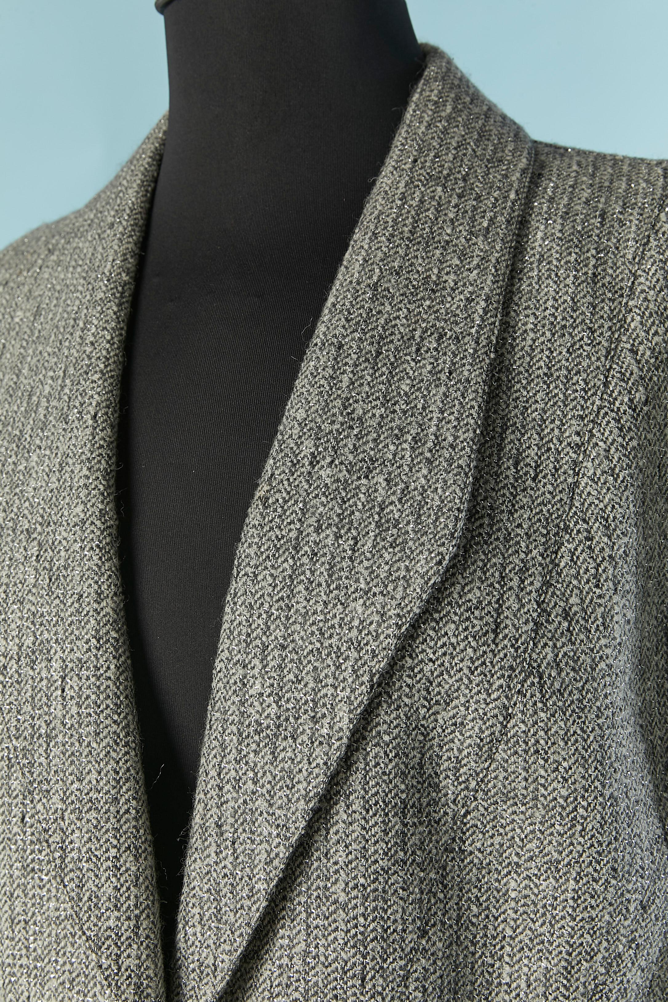 Grey and silver Tweed lurex jacket with chain and star.Main fabric composition: 88% wool, 7% polyester, 5% nylon. No fabric composition tag for the lining but probably acetate or rayon. One snap closure on the middle front on the waist with chain