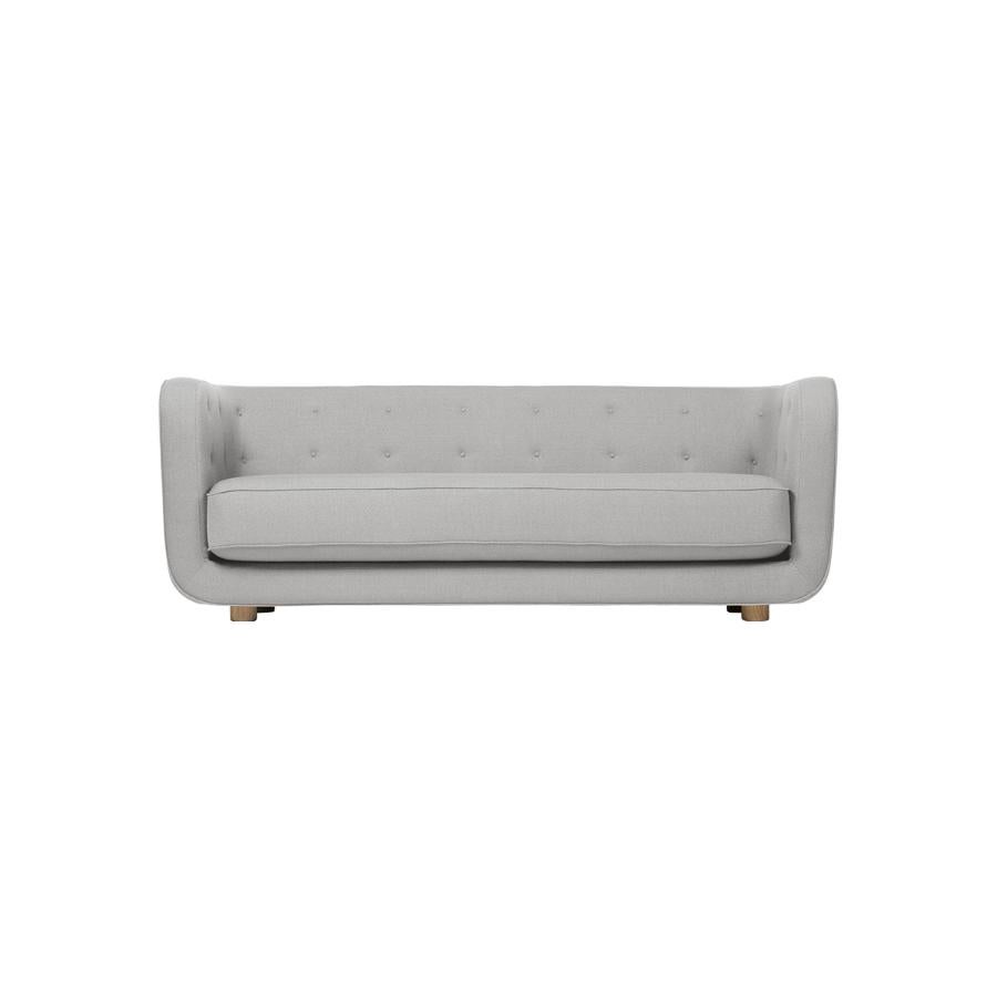 Grey and smoked oak Raf Simons Vidar 3 Vilhelm sofa by Lassen
Dimensions: W 217 x D 88 x H 80 cm 
Materials: Textile, Oak.

Vilhelm is a beautiful padded three-seater sofa designed by Flemming Lassen in 1935. A sofa must be able to function in