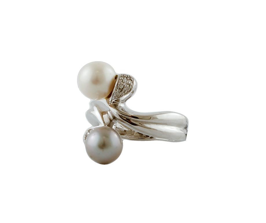 Elegante anello moda contrarié con struttura in oro bianco 18 carati montato con  una perla grigia e una bianca e piccoli diamanti bianchi.
Questo anello è realizzato completamente a mano da maestri orafi italiani.
Diamanti 0.07 ct, taglio