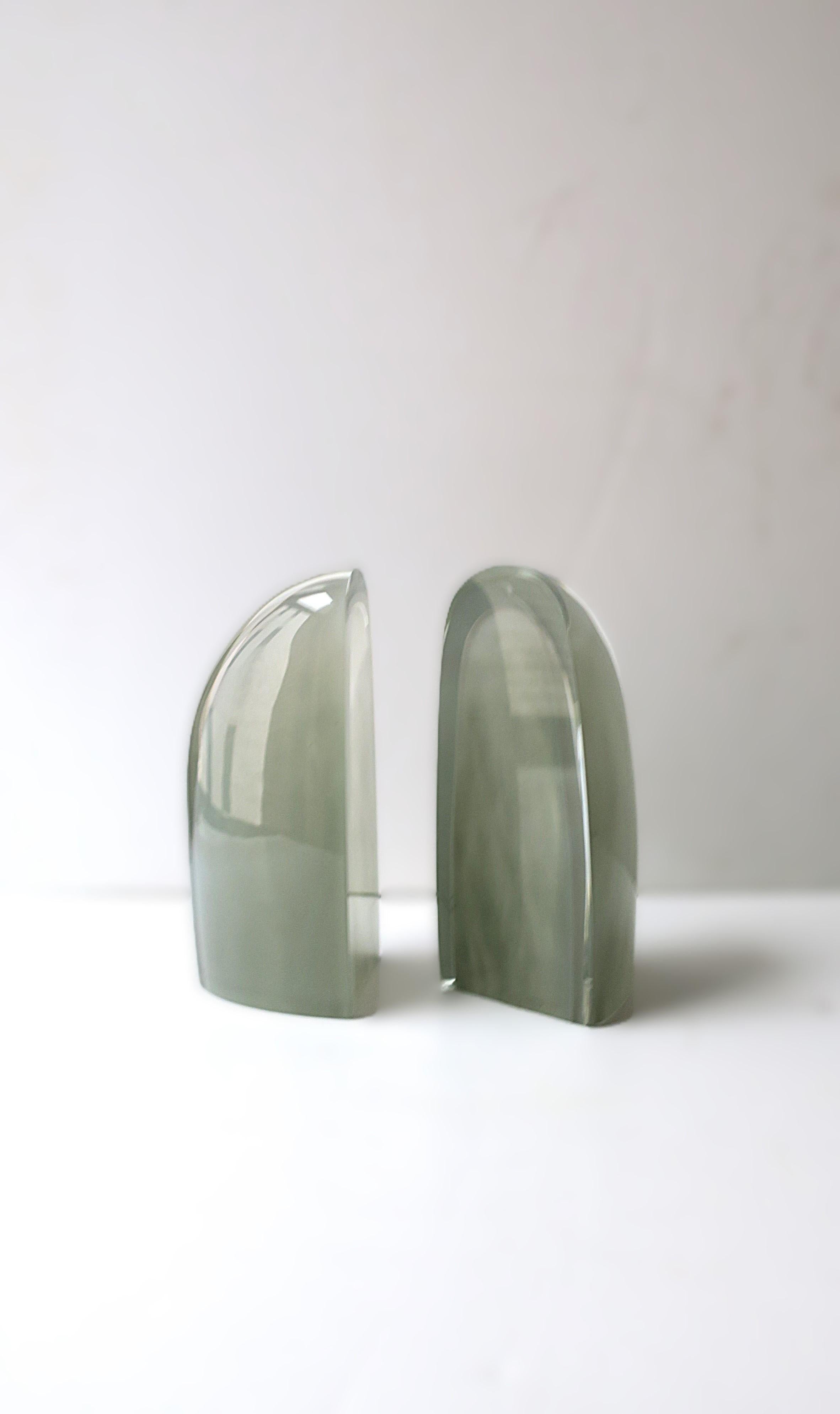 A beautiful and substantial pair of European grey art glass bookends, in the Modern or Organic Modern style, circa early-21st century, Poland. Pair have a soft, oblong shape with a gray art glass interior surround by a clear transparent crystal