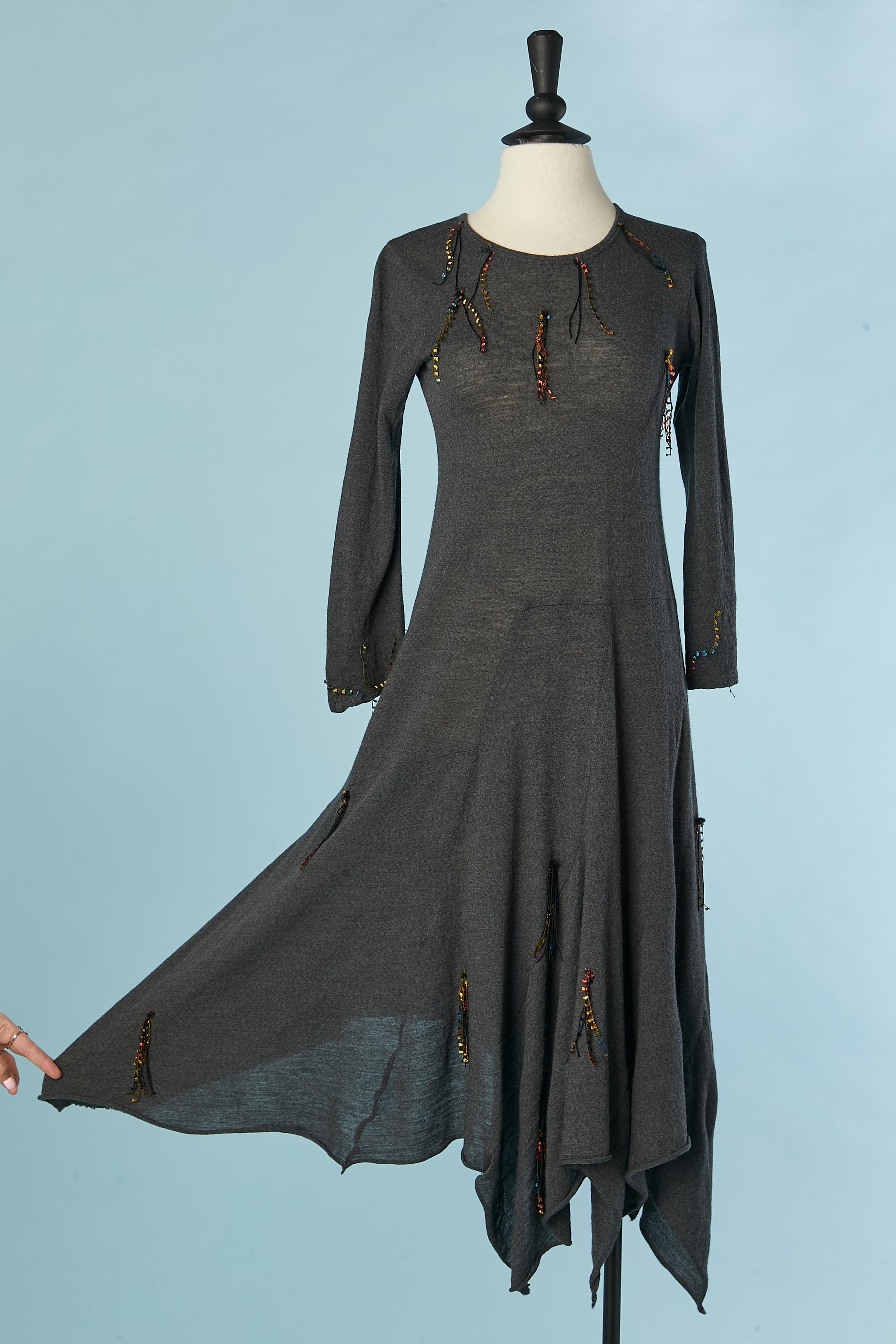 Graues, asymmetrisches Kleid aus Wolljersey mit Bändern und Pompons als Verzierung. Schnittarbeiten. 
Kürzere Gesamtlänge: 110cm
Längere Gesamtlänge: 128cm 
GRÖSSE S 