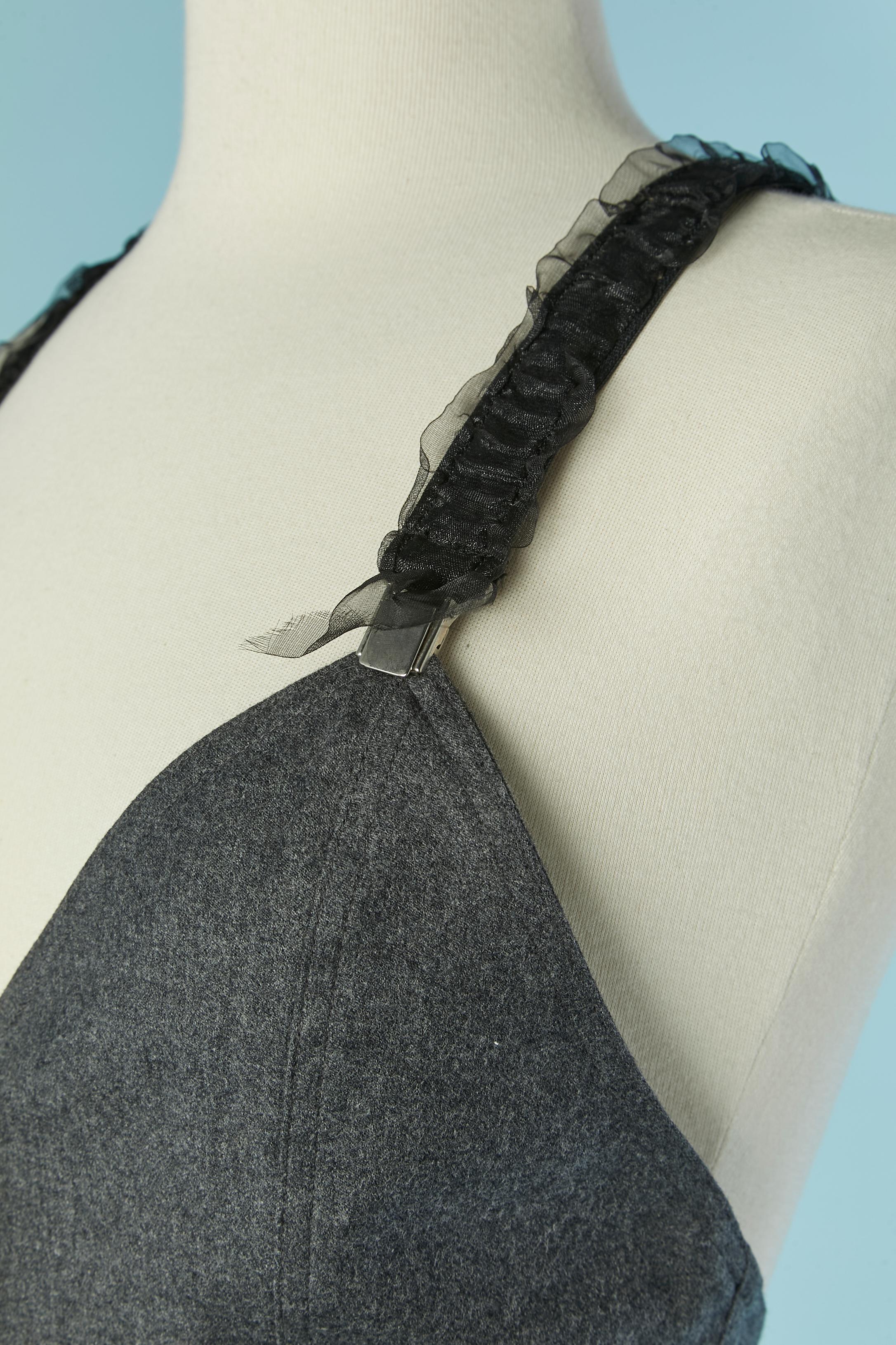 Gilet-bustier grigio con bretelle e nastro lucido sulla parte superiore. Chiusura con bottoni e asole sul centro del davanti. Tasca su entrambi i lati. Stesso tessuto della fodera. Tracolla regolabile.
TAGLIA 36/38 (Fr) S.I.M. 