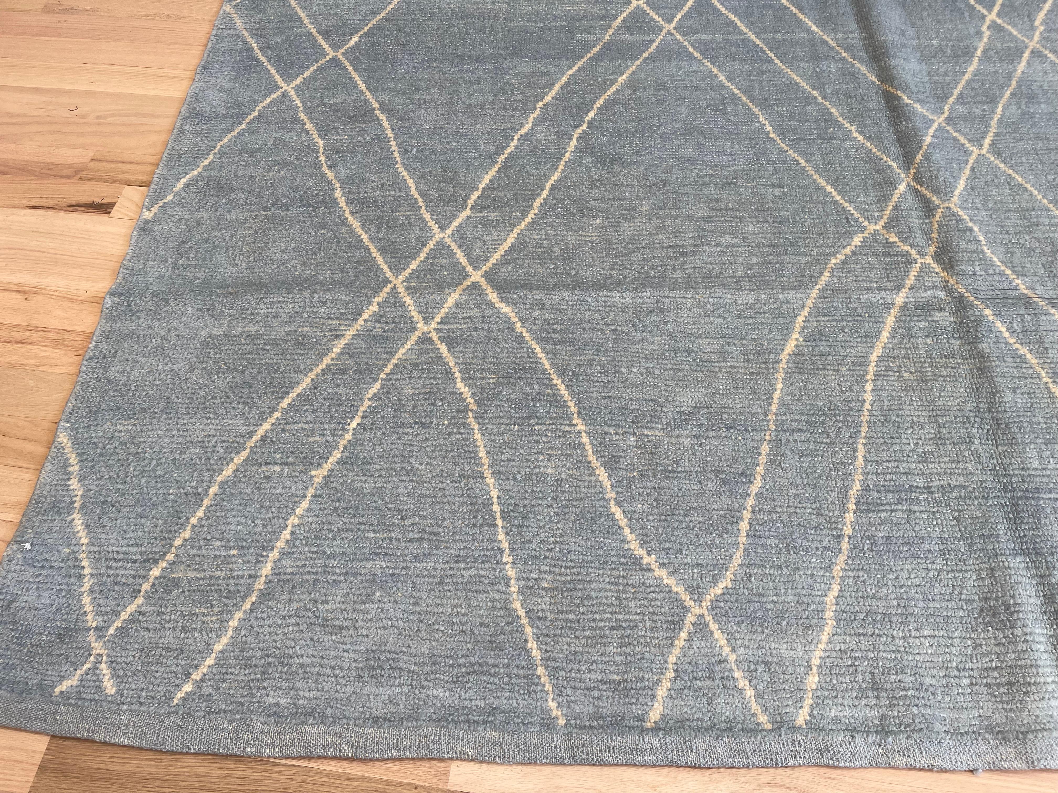 Ce tapis au design marocain est agréable à regarder et doux sous les pieds. Les tons dominants sont le bleu gris et le beige. La base en laine lui confère durabilité, douceur et brillance. Fabriqué en Turquie.