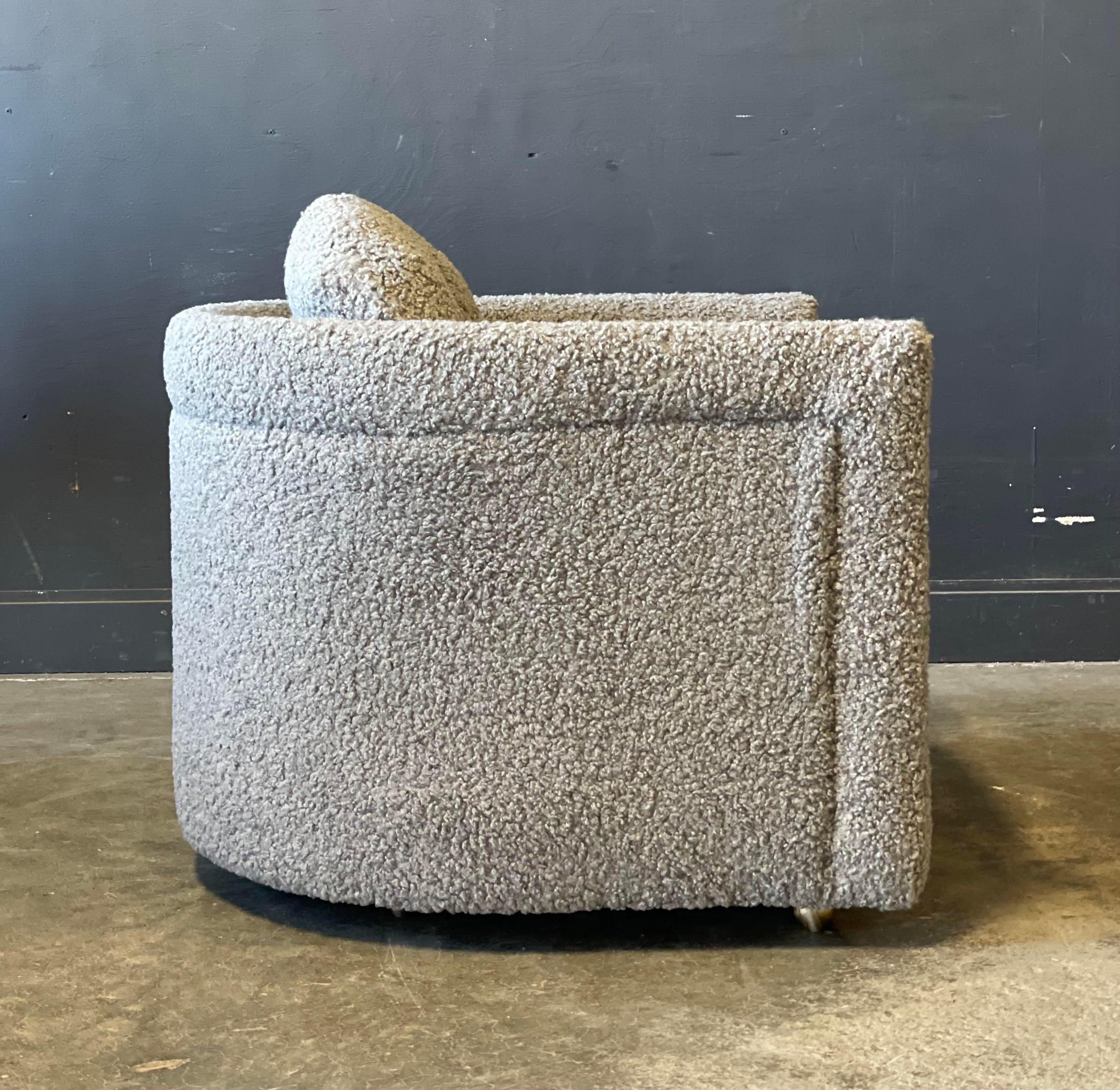 A pair of Mid Century Modern club chairs with soft curves are freshly upholstered in grey boucle. Chairs move easily on brass ball castors. Soft high qualify fabric!