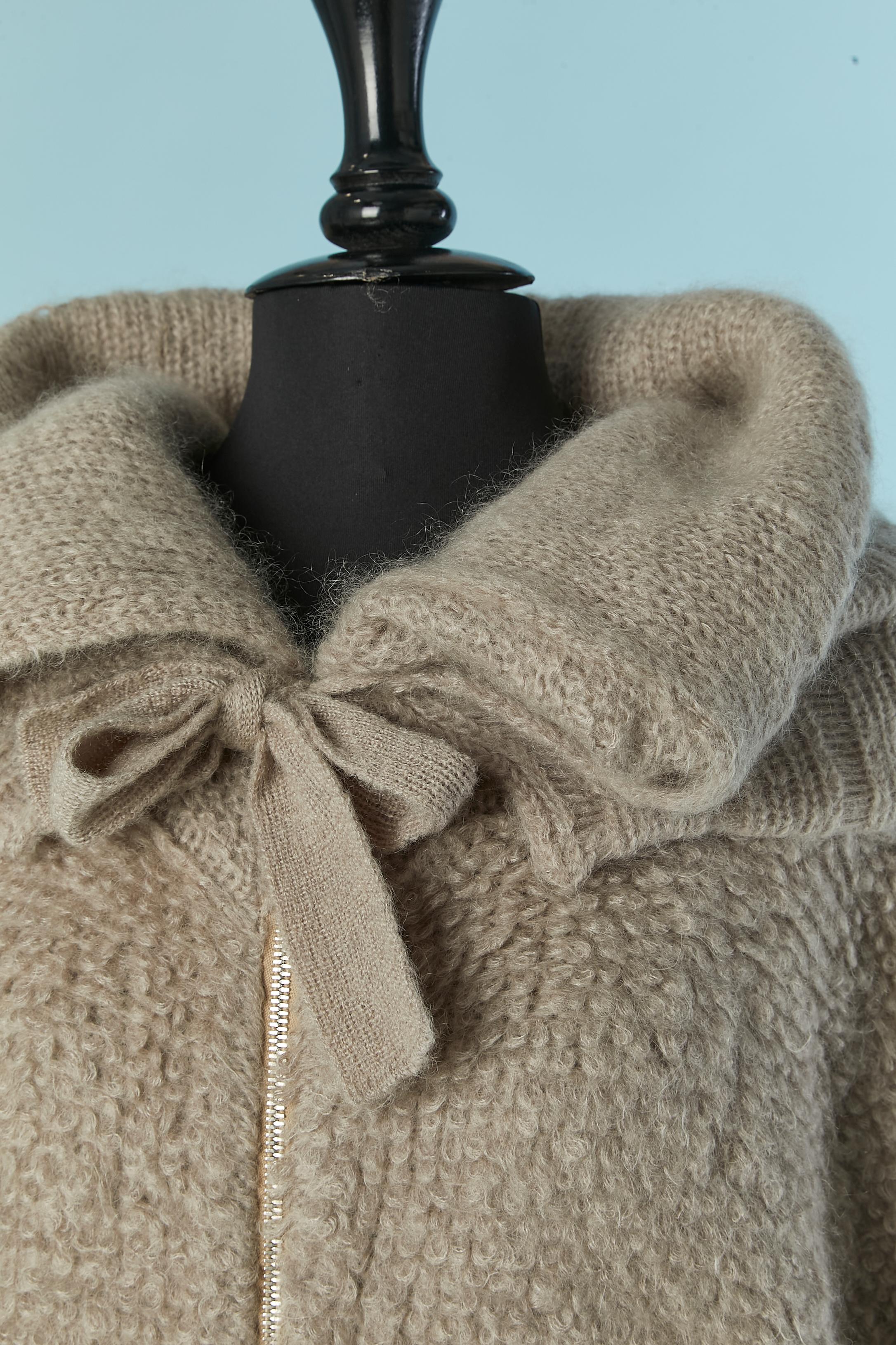 Cardigan oversize en bouclette grise avec fermeture à glissière sur le milieu du devant et tirette de fermeture à glissière de marque.  Composition du tricot : 66% mohair, 30% polyamide, 4% laine. Pochette sur les deux côtés. Fermeture par un nœud