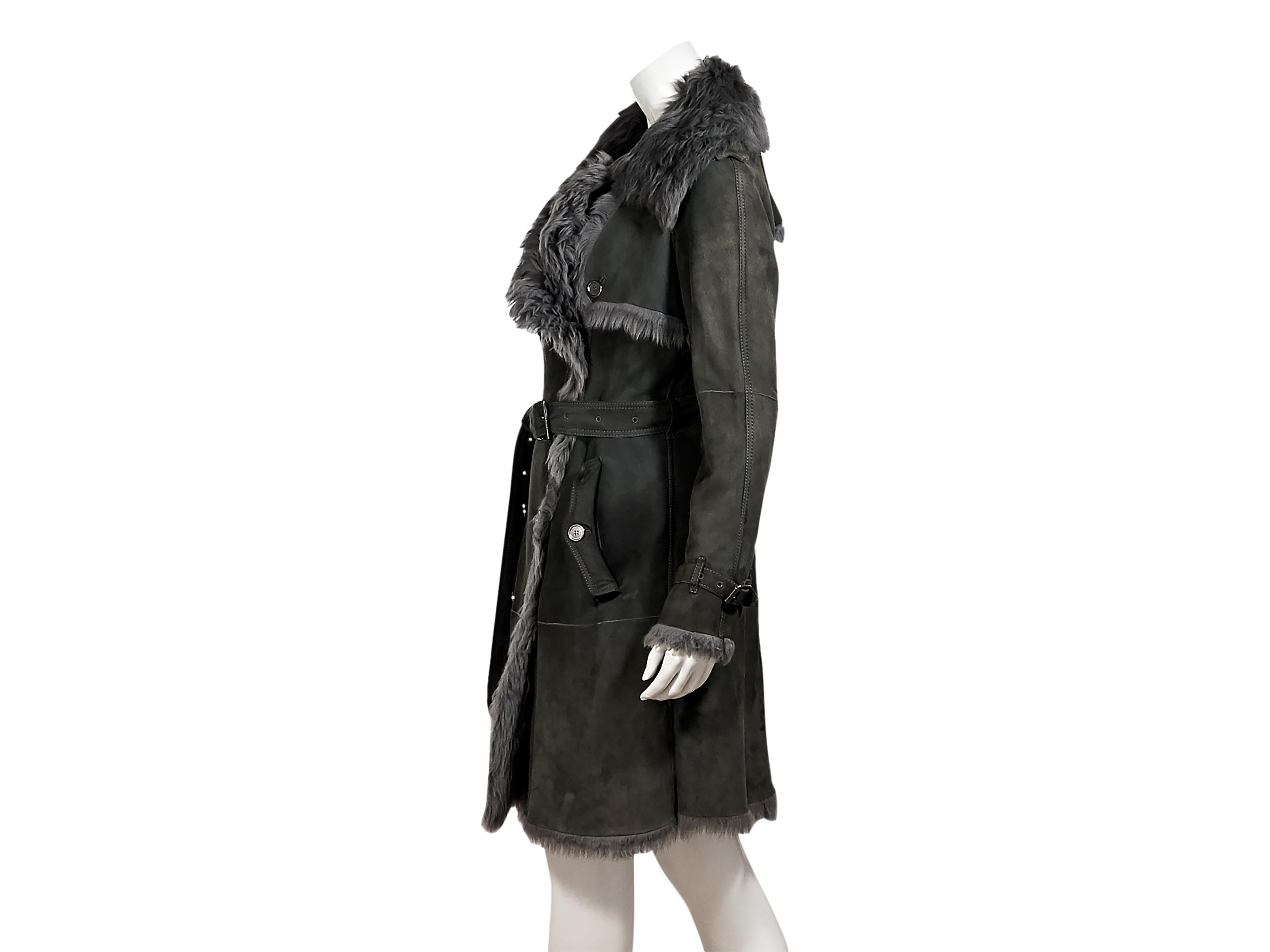 Product details:  Grey shearling trench coat by Burberry London.  Oversized notched lapel.  Long sleeves.  Double-breasted button-front closure.  Adjustable belted waist.  Waist button flap pockets.  Back storm vent and center hem vent.  30