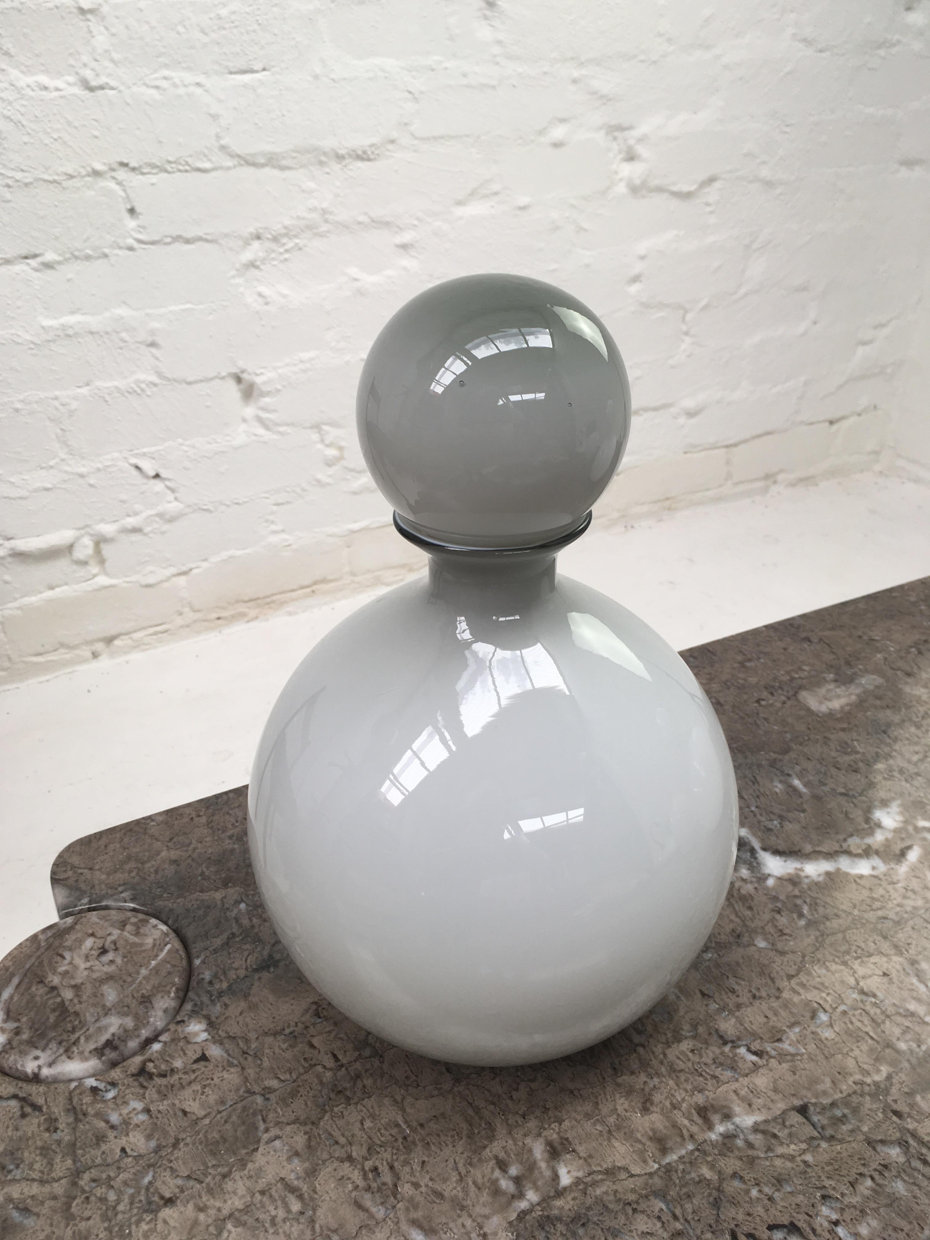 A cased glass ball-stoppered bottle in Empoli* glass. The light Grey glass graduates in thickness which give a very pleasing Ombre colour effect. 

It's in very good condition and while it is not the largest size we've seen, it is still generous -