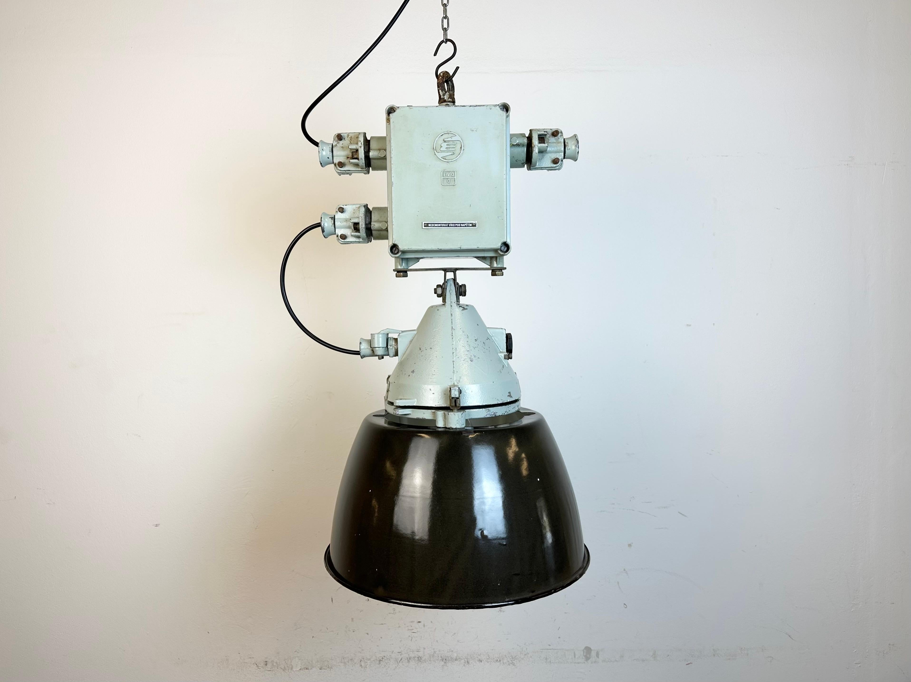 Grey industrial lamp with massive protective glass bulb made by Elektrosvit in former Czechoslovakia during the 1970s.It features a grey cast aluminium body, a clear glass and a black enameled shade with white interior. Porcelain socket requires