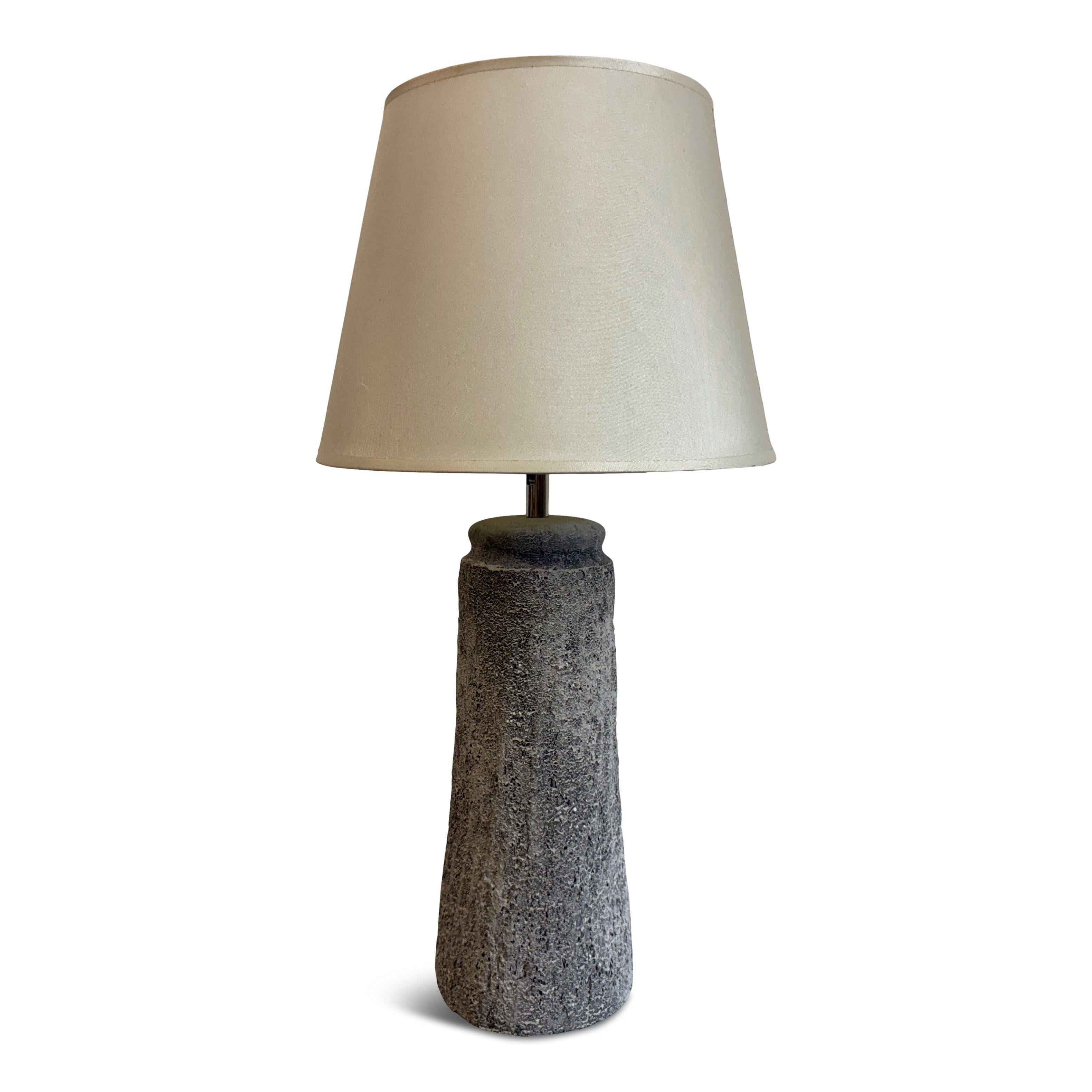 Ceramic table lamp

A striking ceramic table lamp with a sculptural, textured base that exudes a raw, organic charm. The base, with its irregular surface and tapered form, has an almost volcanic stone-like appearance, lending a sense of earthy