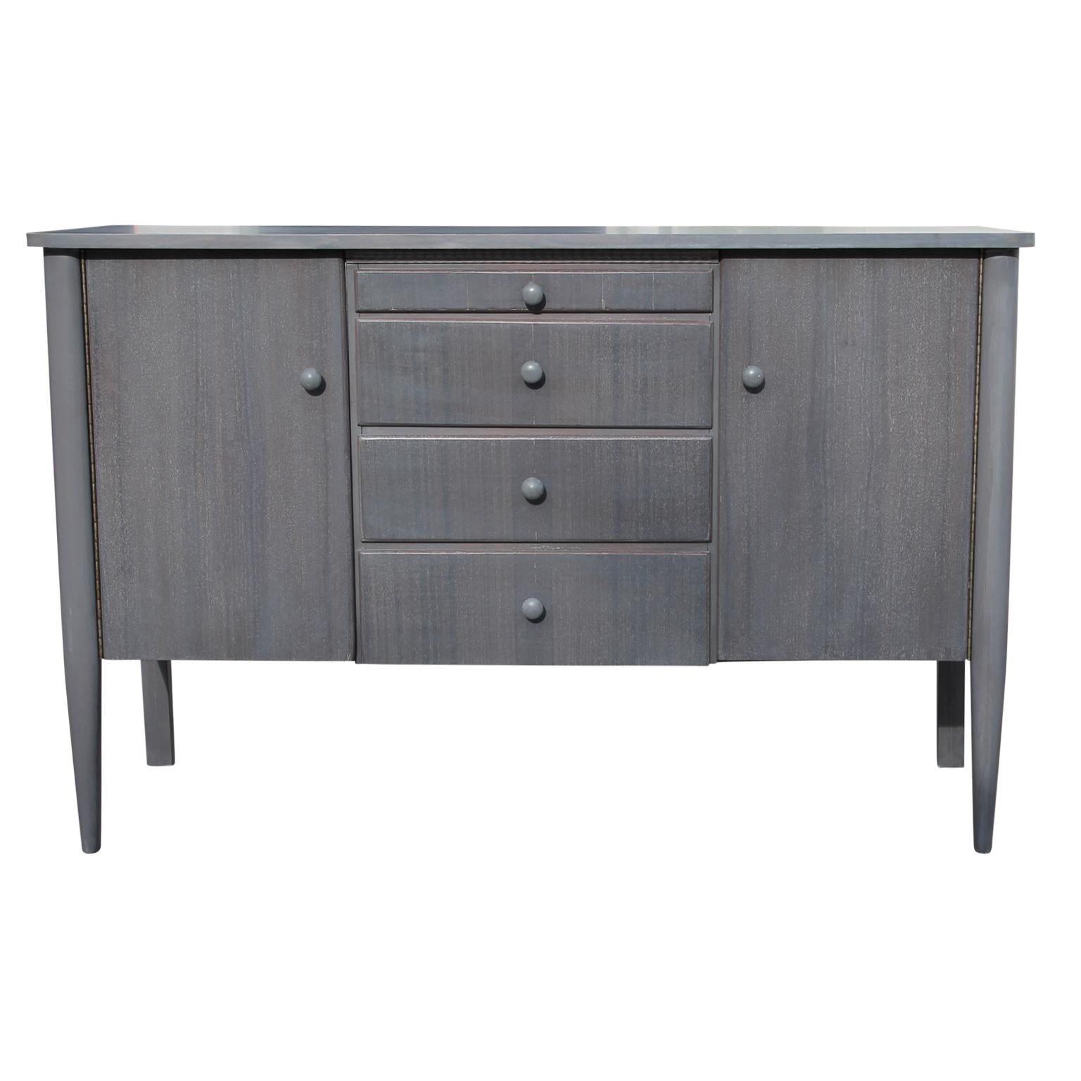 Grey cerused modern Danish style sideboard with two side cabinets on either side and three center drawers. The top one has an organizer and the very top thin one is a writing surface.