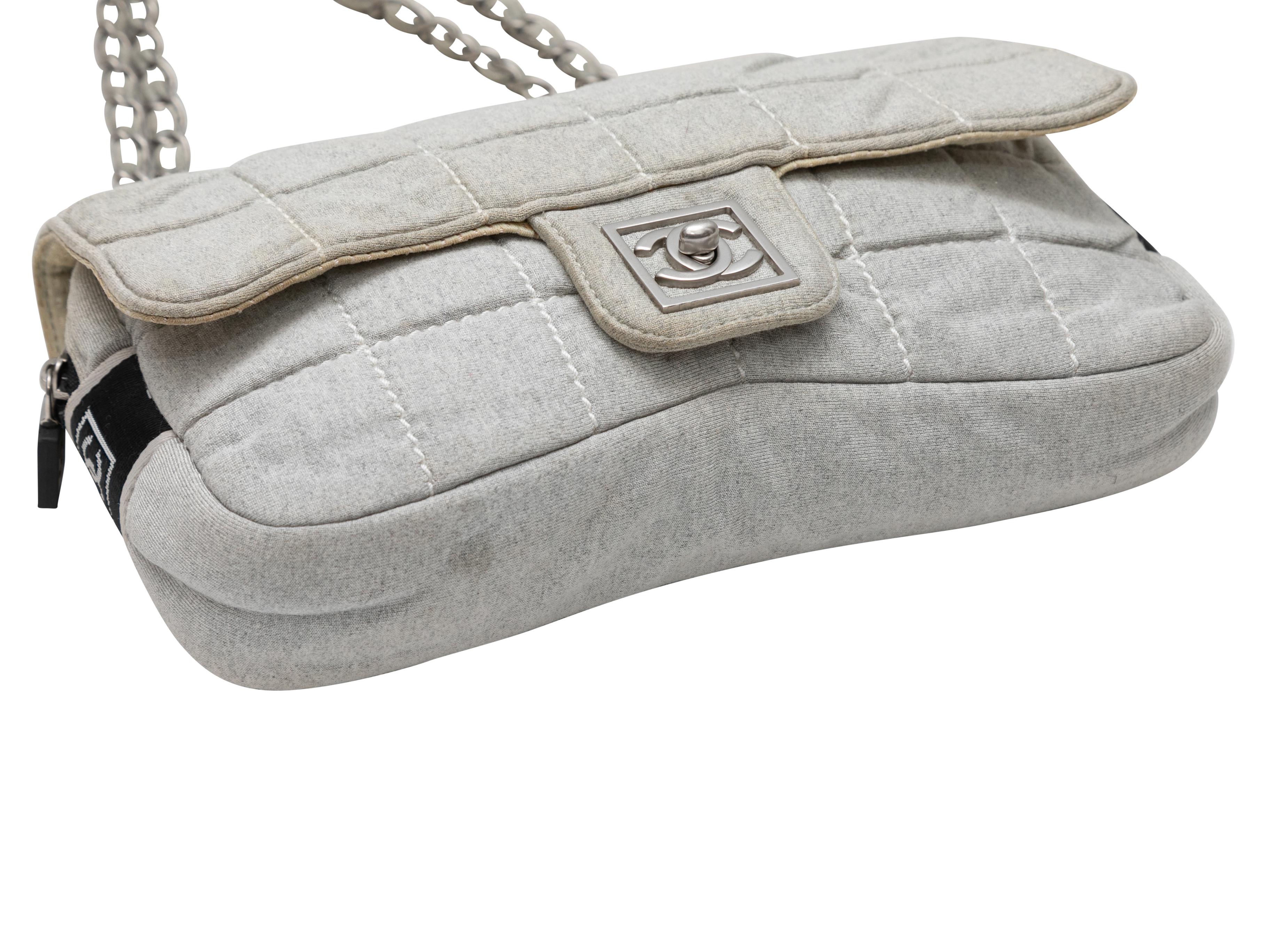 Bolso de hombro Chanel 2006 de punto acolchado gris. Este bolso bandolera tiene un cuerpo de punto acolchado, herrajes plateados, correa doble de tela y eslabones de cadena, cremallera superior y cierres de giro CC delanteros. 11