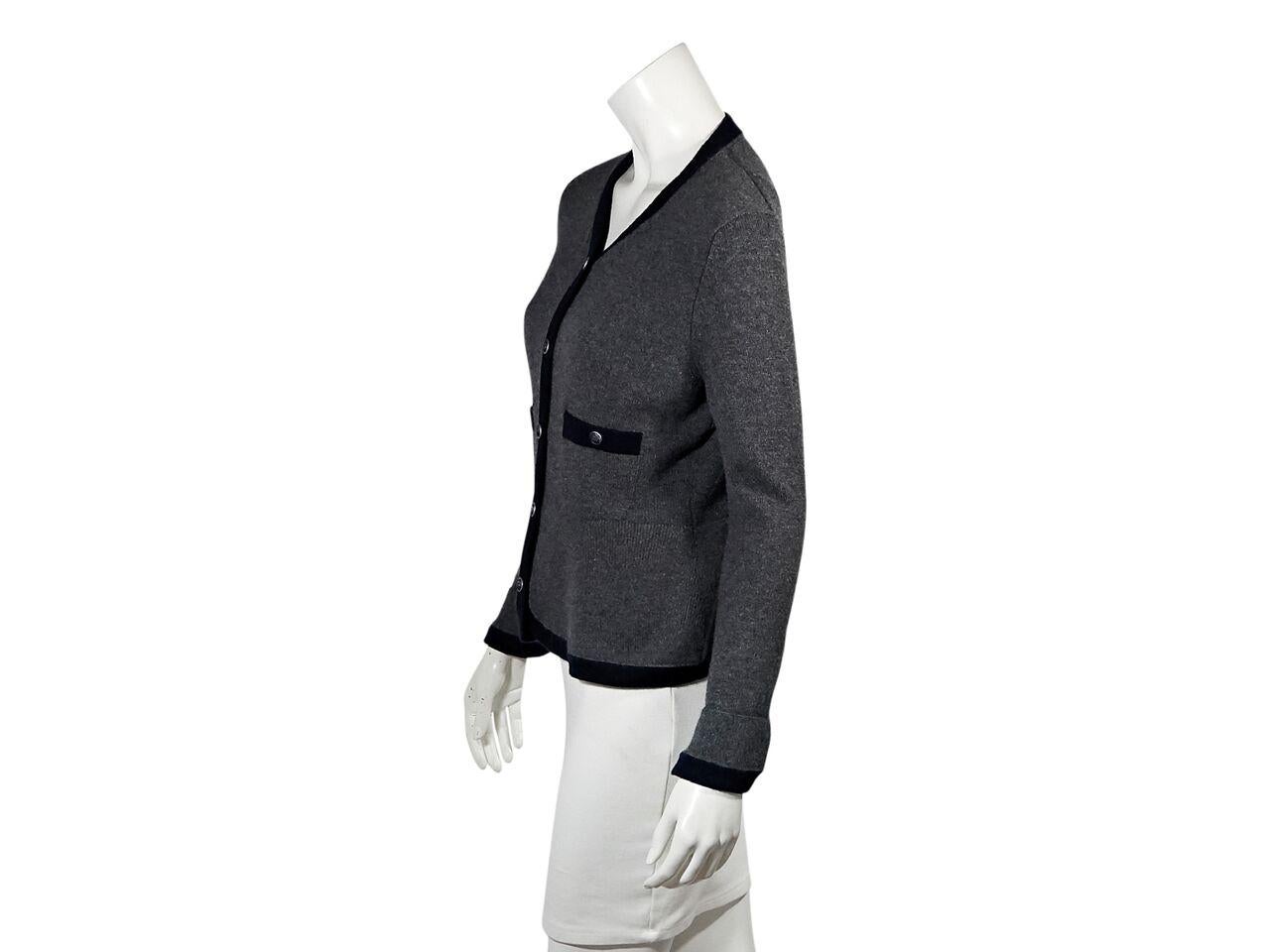 Product details:  Grey cashmere cardigan by Chanel.  V-neck.  Long sleeves.  Button-front closure.  Bust button patch pockets.  Silvertone hardware.  Label size FR 38.  34